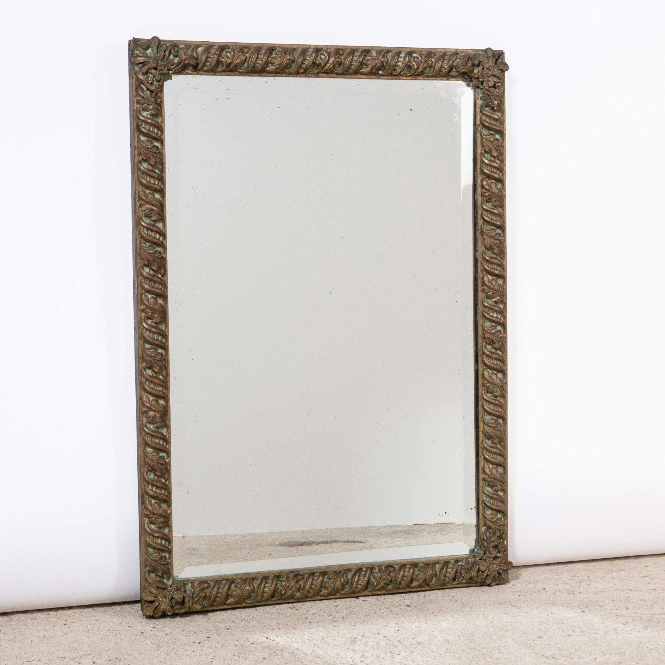 Unique Arts & Crafts style rectangular mirror featuring a decorative copper frame adorned with an intricate scrolling leaf design, showcasing a delightful patina.

Mounted on wood, the copper frame boasts gracefully scrolling ribbons and leaves,