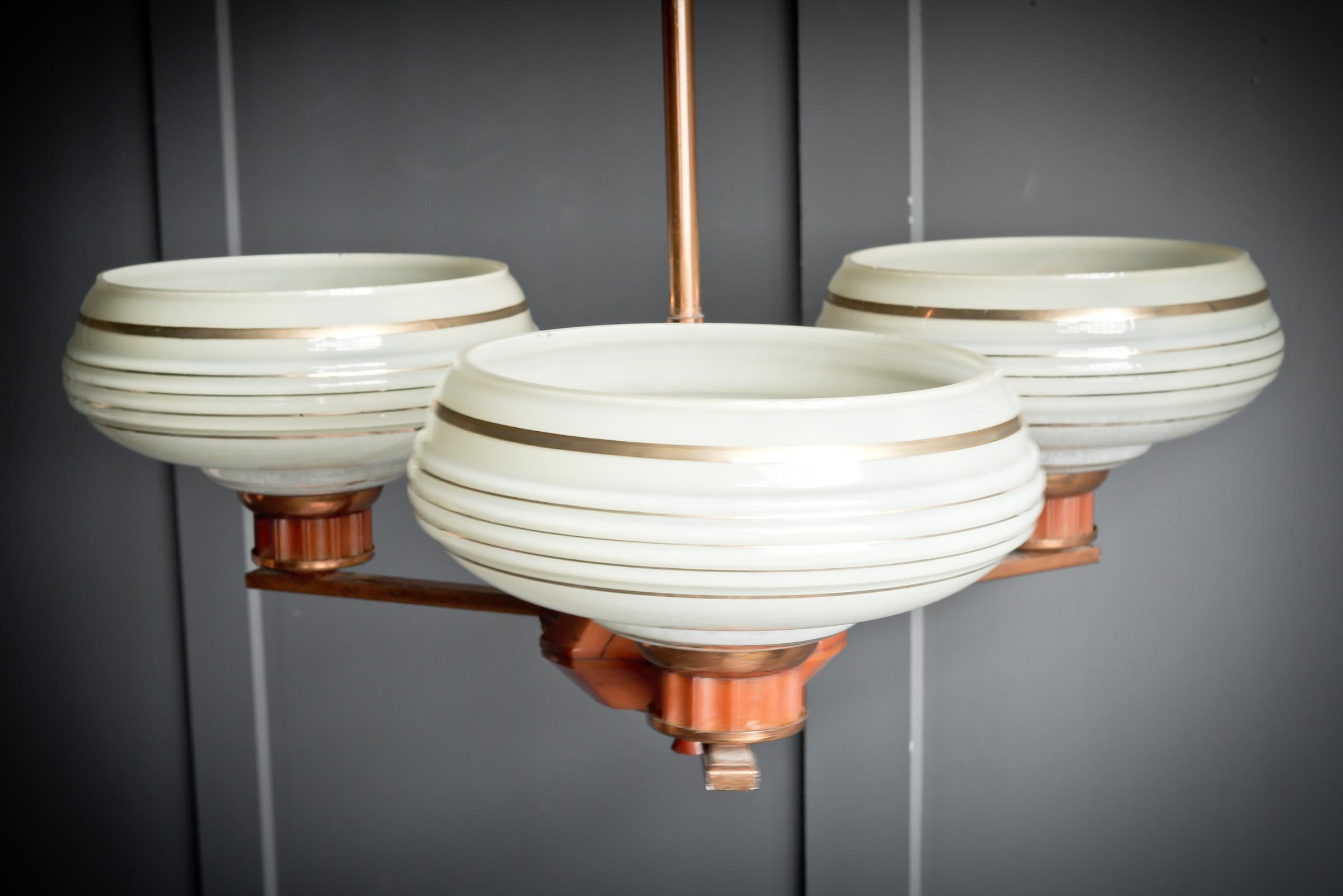 Copper Bakelite triple pendant light typical of the art deco period of the 1920s.