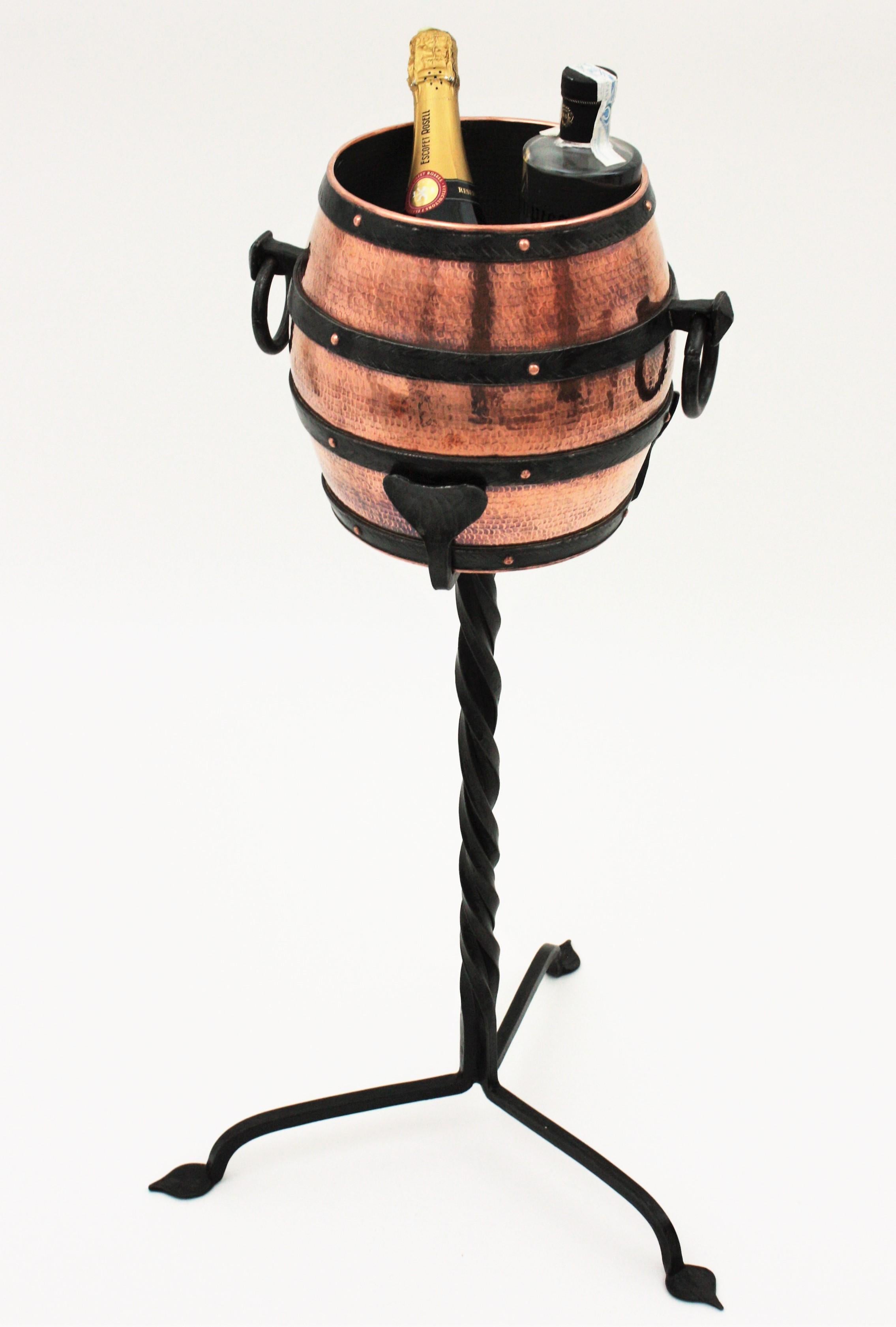 One of a kind hand forged copper and iron barrel shaped wine cooler stand, Spain, 1930s-1940s.
This tripod stand champagne serving set is all made by hand. The handwrought iron stand has a tripod base with twisting details and supports a large