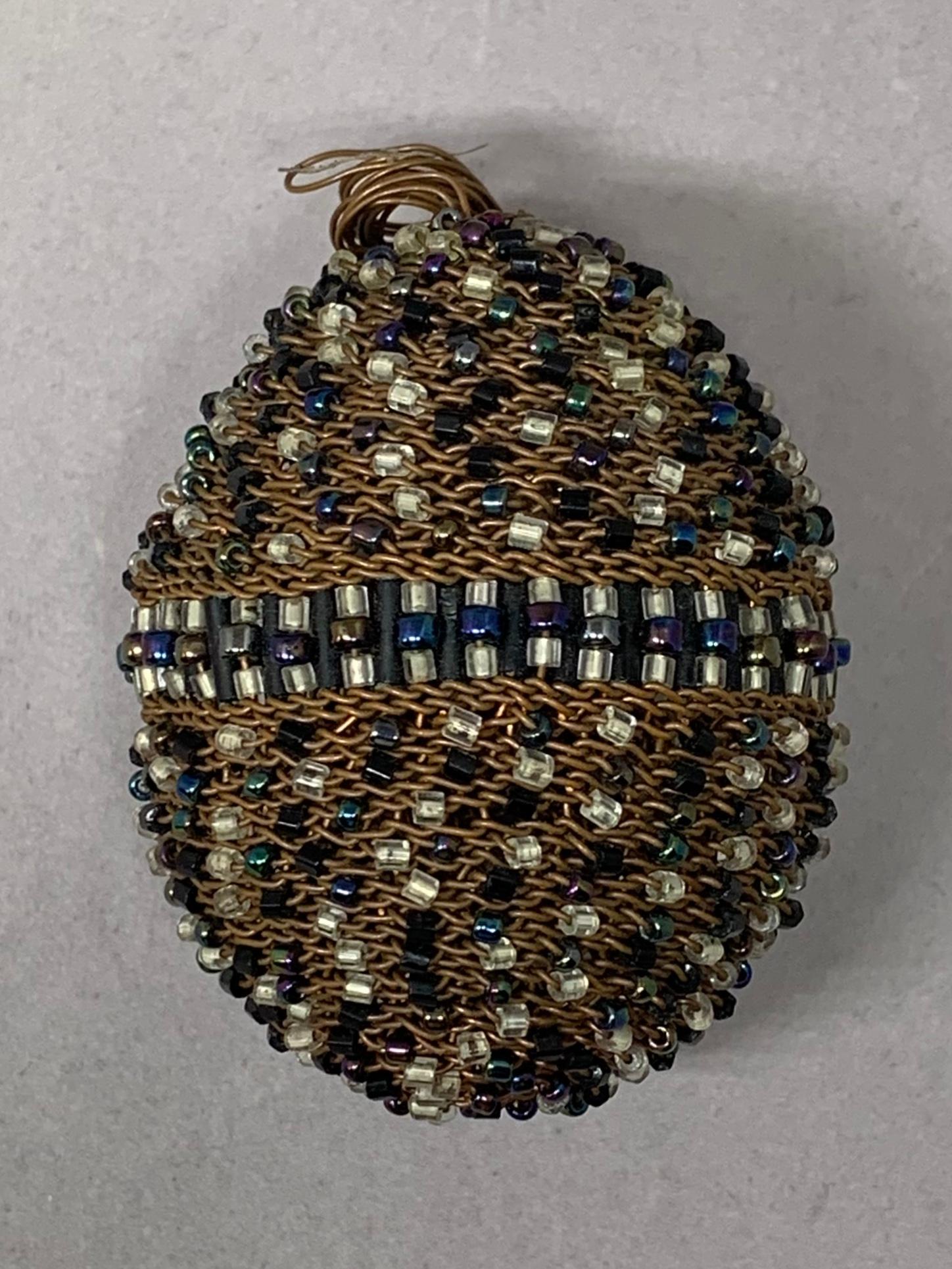 Copper beaded egg with nest. Handmade Easter/Spring egg of copper wire and iridescent and clear beading with small bird’s nest; possibly Northern Parula. United States, contemporary.
Dimensions: nest 4.5