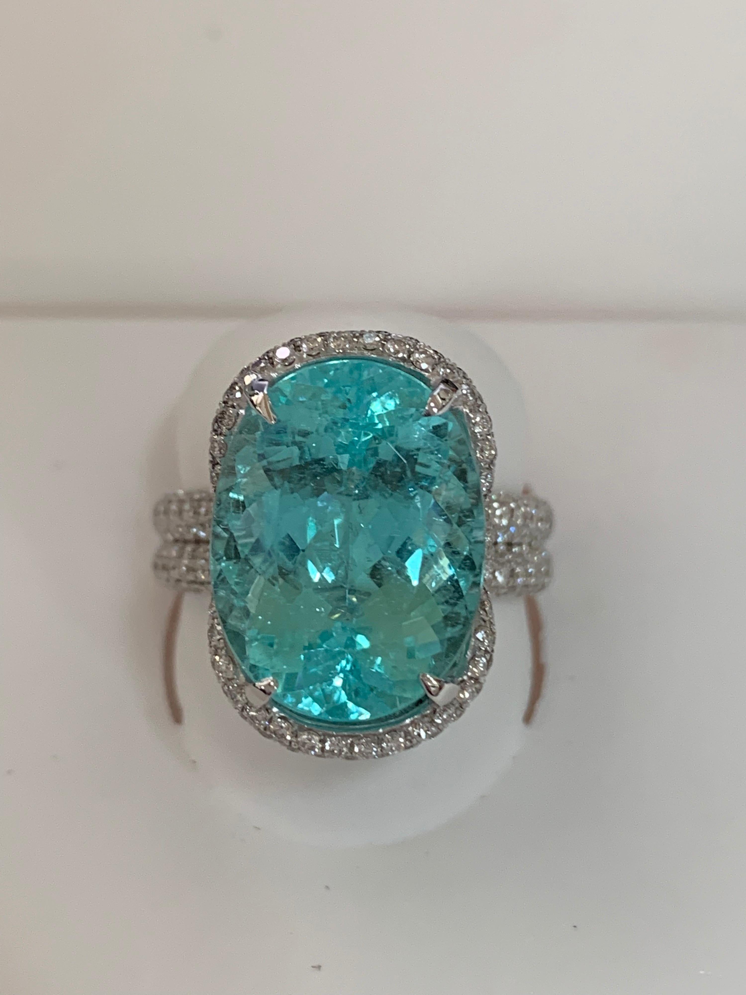 Oval natural 11.53 Carat Paraiba Tourmaline and white round 1.60 Carat diamond set in 18 Karat gold is one of a kind handcrafted ring.
The ring is size 8 but can be resized if needed.