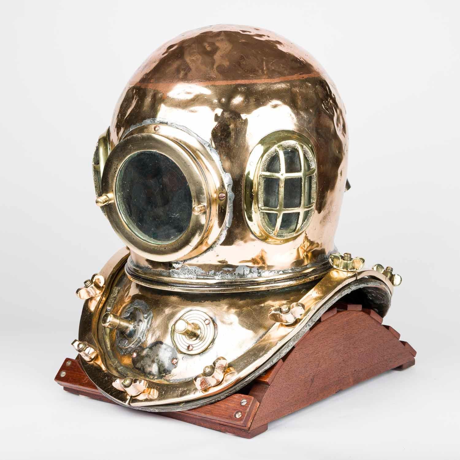 A copper and brass 12 bolt, 3 light, diving helmet, Korea, circa 1950.

Mounted on later display stand. 

Attributed to KIM of Busan.