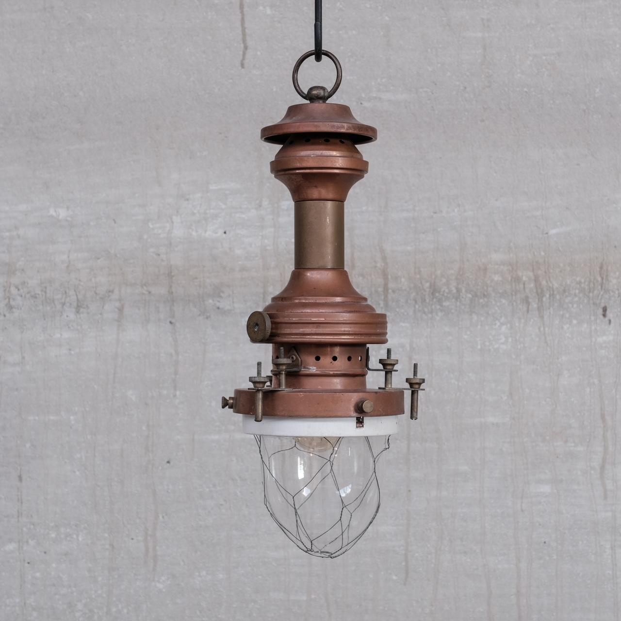 An early 20th century, brass and copper pendant light, with glass domed base encased in wire caging. 

France, c1930s. 

Good vintage condition, with authentic natural patina. 

No original chain or rose was retained, these are sourced easily