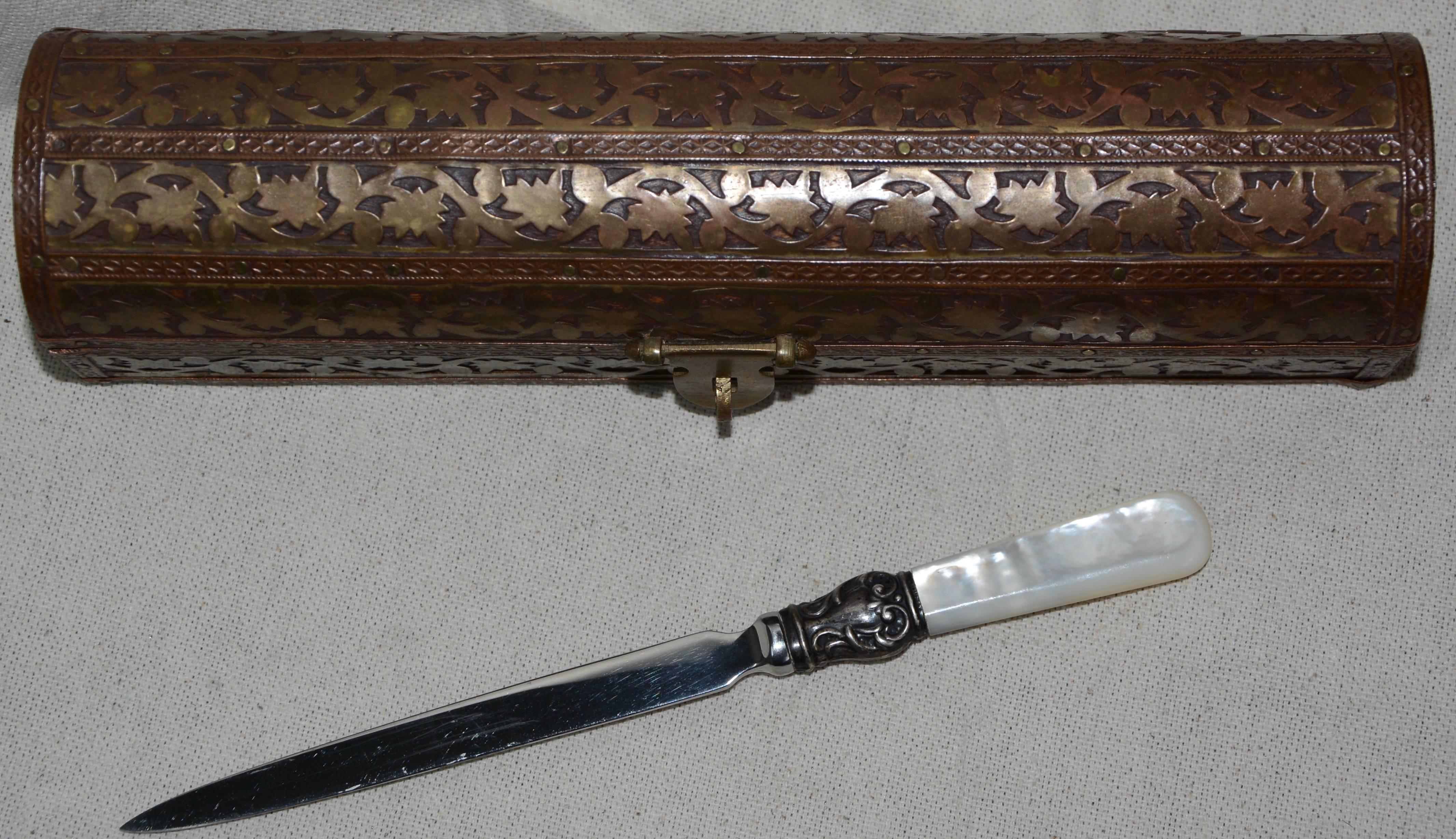 The brass inlay on this teak handcrafted box is exquisite. It is framed by ribbons of copper which have been attached with tiny brads. The closure is formed of brass. Inside the box you will find a letter opener with a smoothly finished mother of