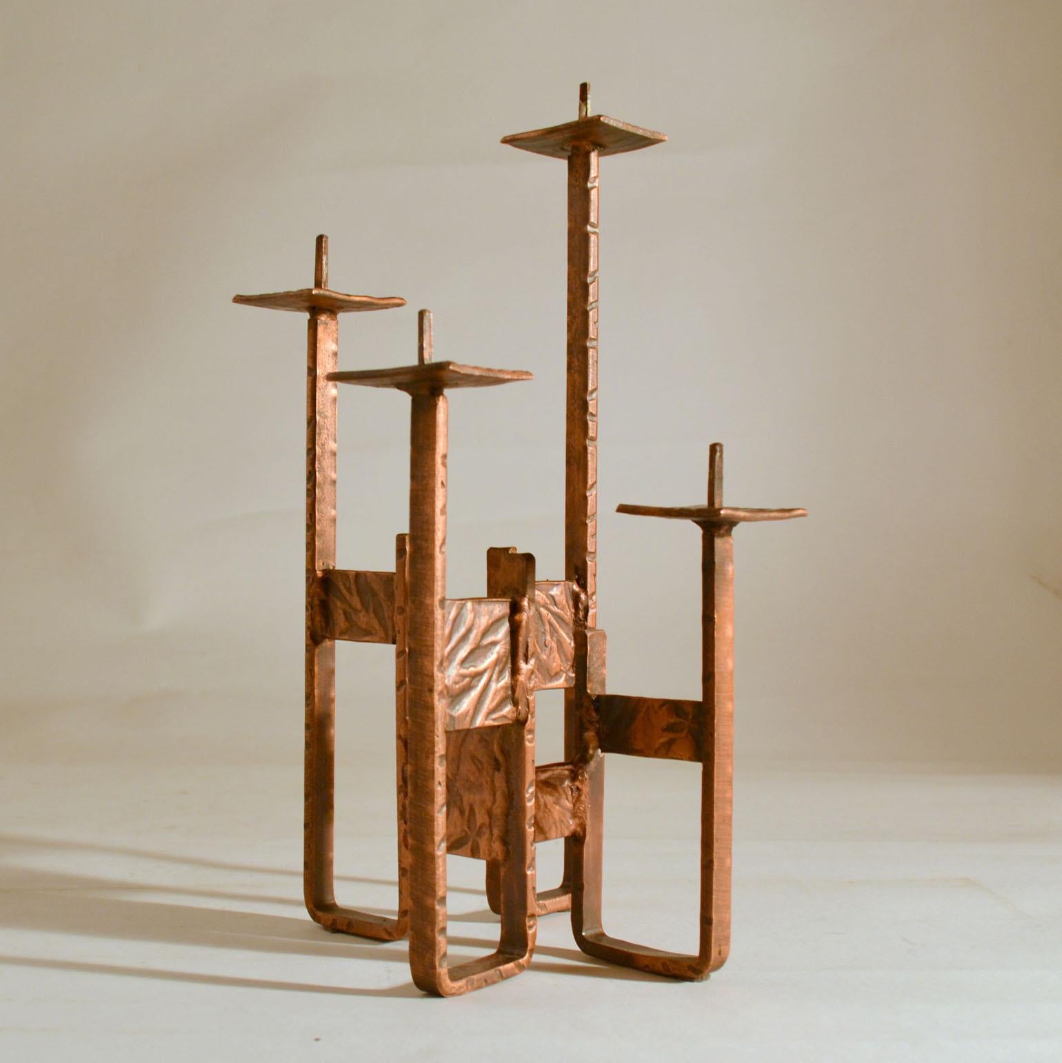 Candelabra for four candles on alternating is created in stationary positions, made in copper with hammered texture, Germany, 1970s. They can hold standard candles or pillar candles, 3-4 cm diameter.