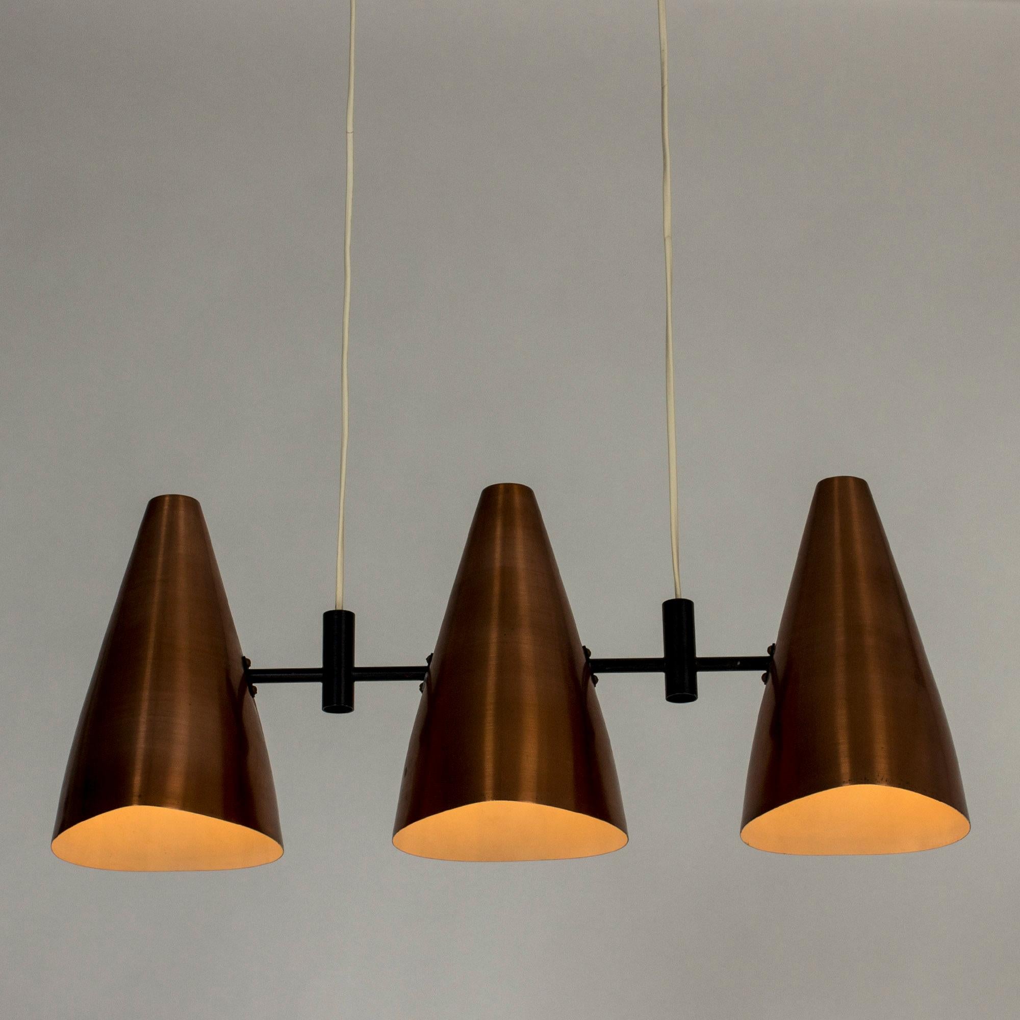 Very cool ceiling lamp by Eje Ahlgren, with three copper shades. Sleek graphic look with black lacquered details and a long, boxy ceiling cup.