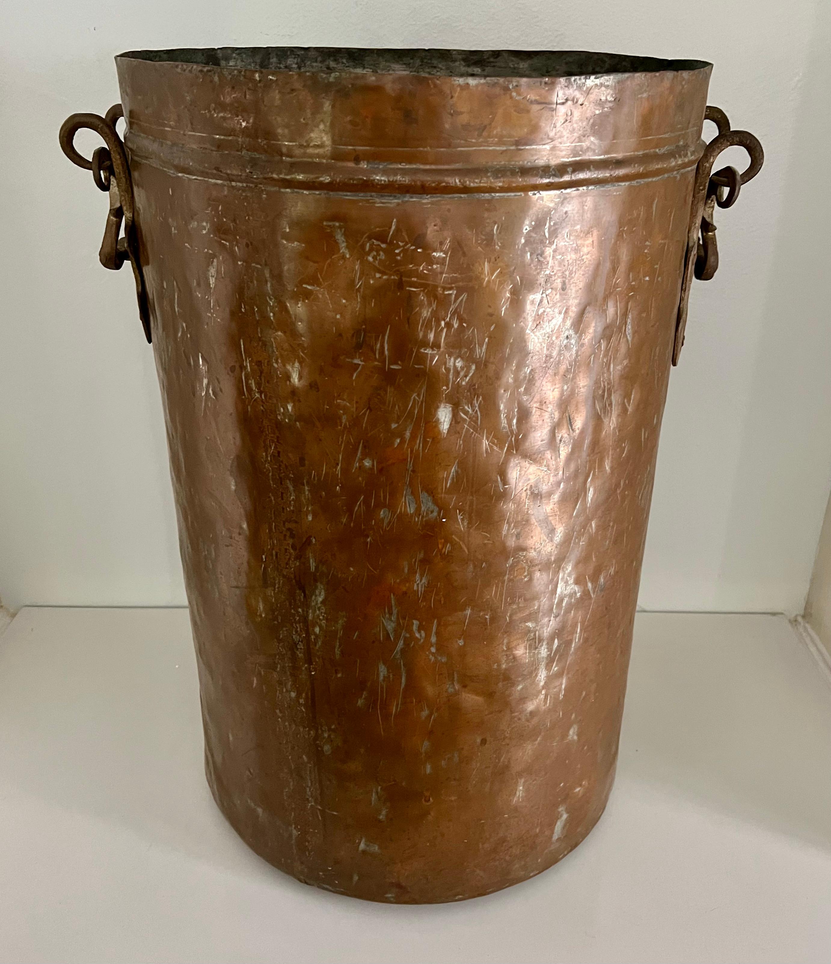 A very large and tall copper bucket, perfectly suited for firewood, coal or even as a planter, jardiniere. The piece is very well made and has substantial hand wrought handles. A lovely piece for the kitchen cabin or fireplace.