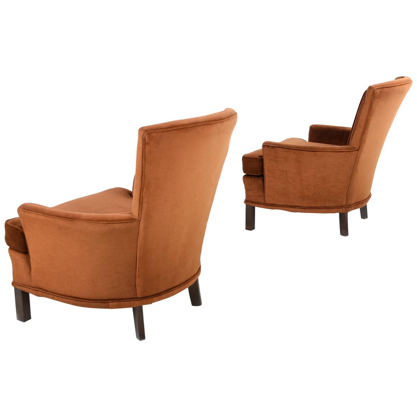 This charming pair of vintage armchairs come outfitted in their original rich velour upholstery. The nutty, copper toned, brown fabric is plush and inviting. A whimsical quilted medallion embellishes the backrest of these ever-so-quaint lounge