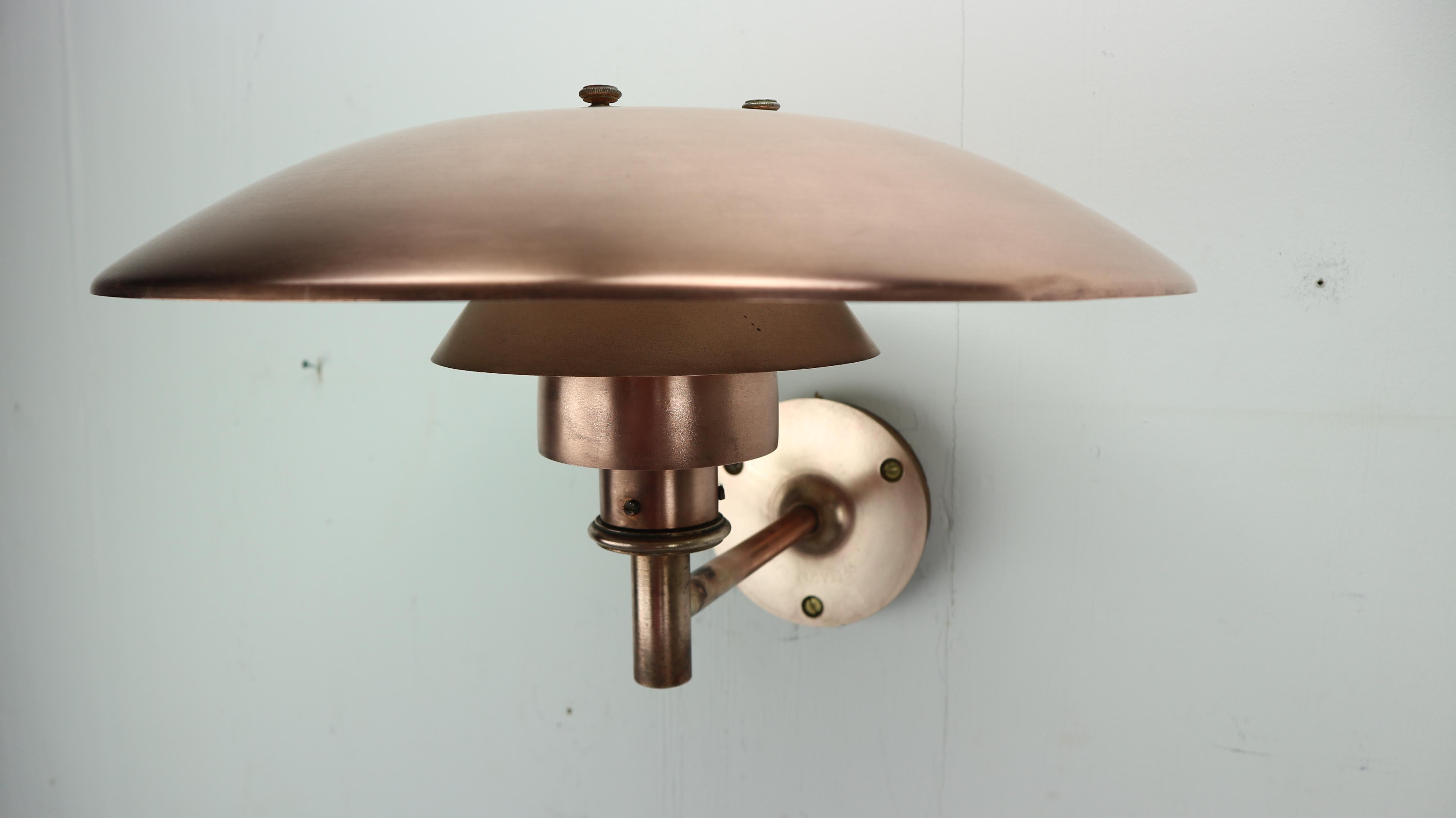 This unique wall lamp is designed by Poul Henningsen for Louis Poulsen in 1960 circa and made in Denmark.
Copper lamp is having age-related patina.
The lamp’s design is based on the IDEA of a set of reflective shades which create balanced,