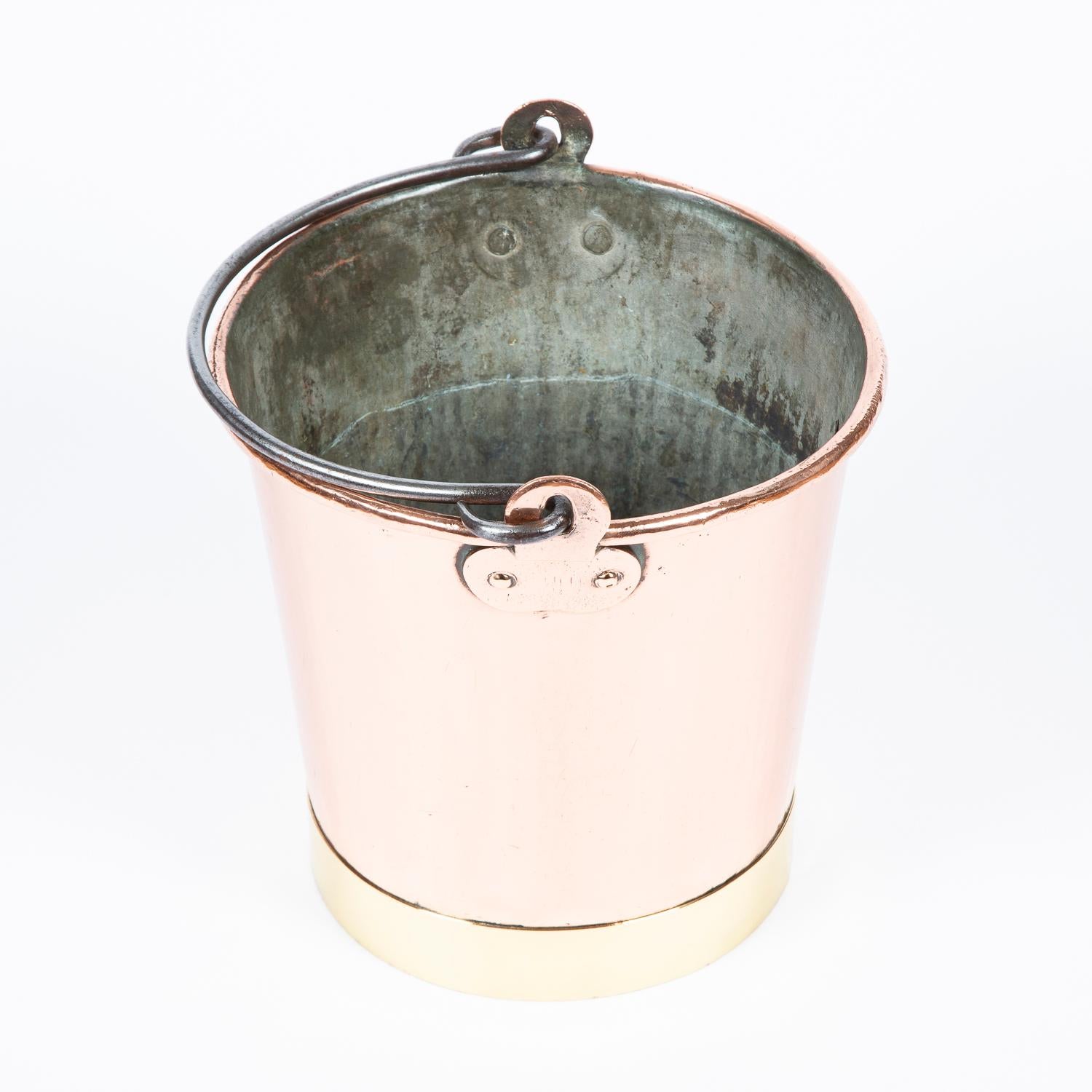 Copper fire bucket with brass base and iron handle.

Suitable size to be used as a planter or wine cooler.