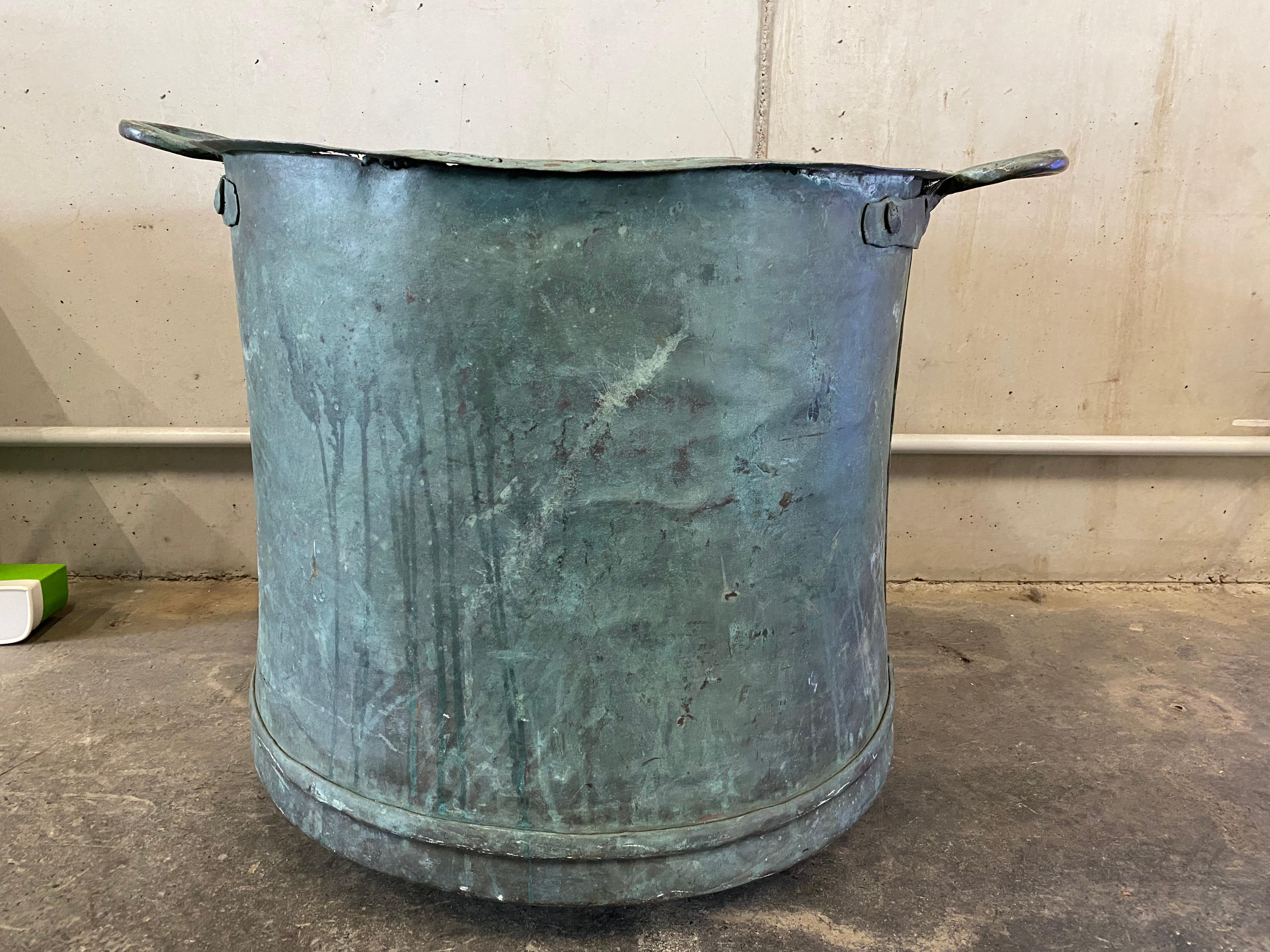 Unique copper bucket from the 1800's. The copper has oxidized over the years and developed a beautiful patina. The riveted handles also suggest the age of the bucket. In addition, they are a very nice detail on the antique piece. The bottom of the