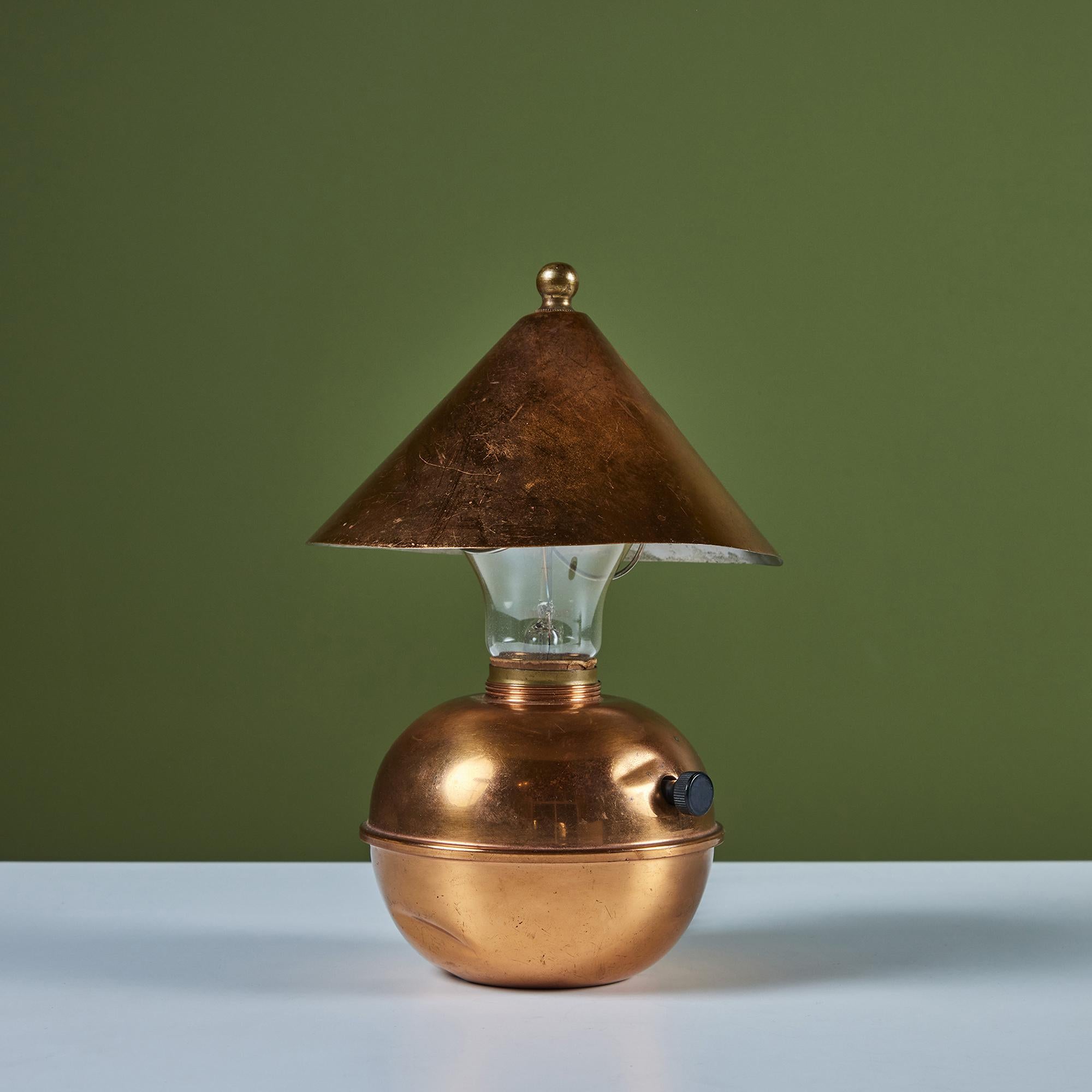 Petite copper table lamp by Ruth Gerth for Chase, c.1930s, USA. The Art Deco lamp features a cone shaped shade and bulb body in patinated copper. The minimalist design is playful and a fun piece to add to a shelf or desk.  Impressed with [Chase] and