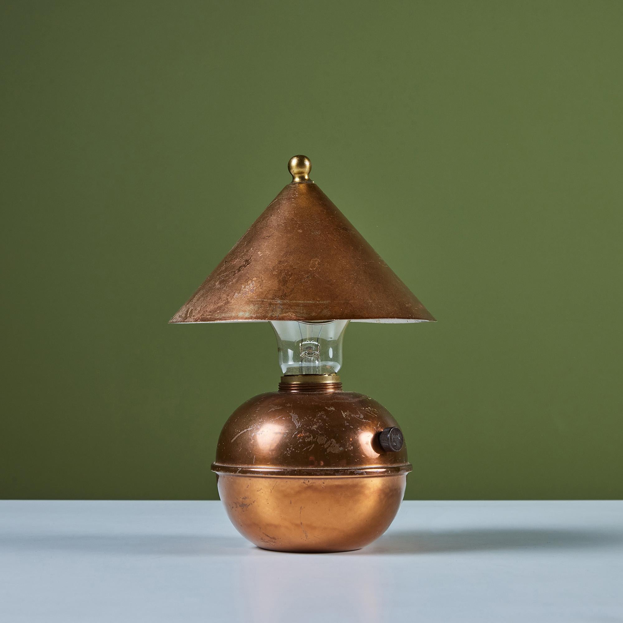 Petite copper table lamp by Ruth Gerth for Chase, c.1930s, USA. The Art Deco lamp features a cone shaped shade and bulb body in patinated copper. The minimalist design is playful and a fun piece to add to a shelf or desk.  Impressed with [Chase] and