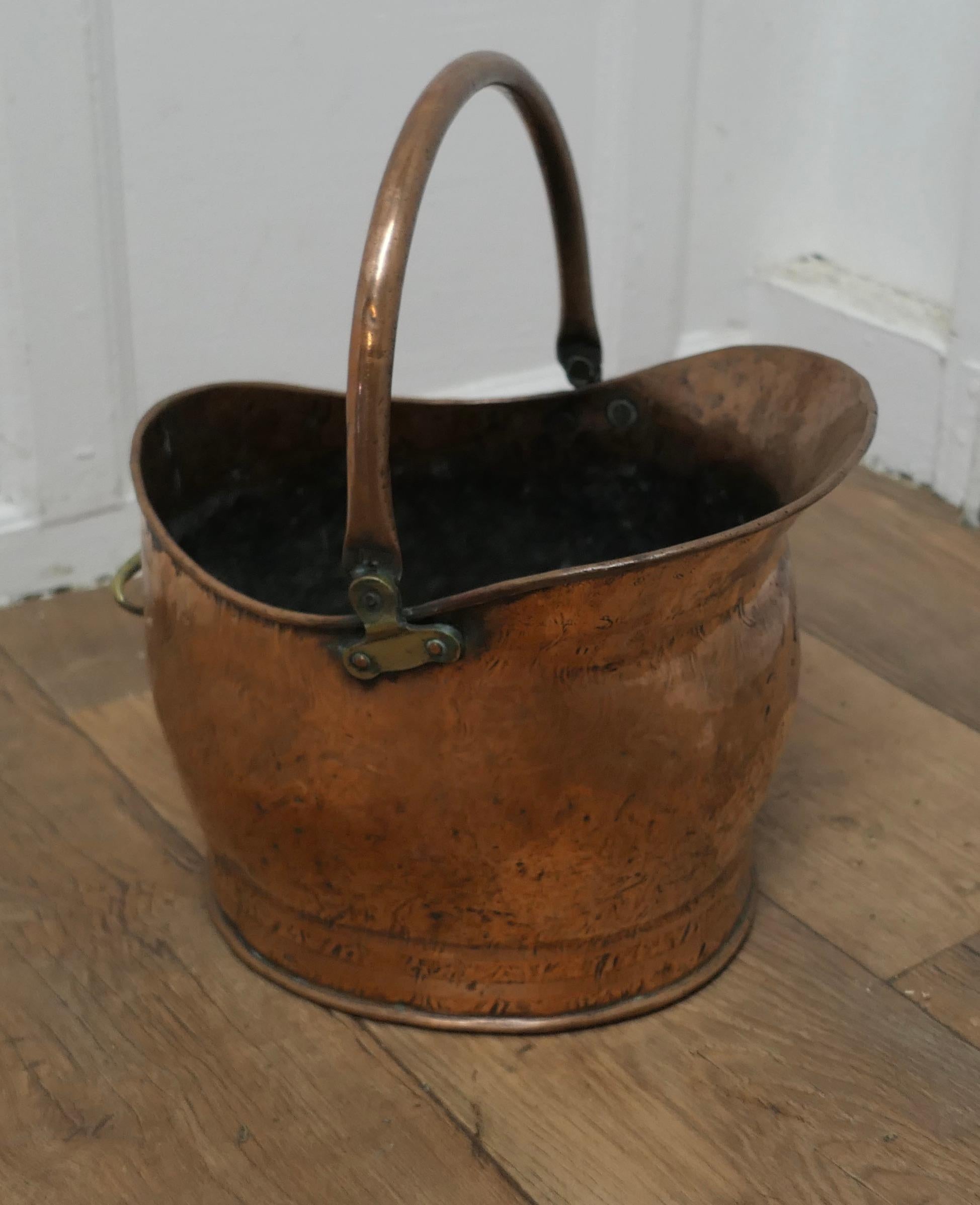 Copper Helmet Coal Scuttle 

This bucket is a very attractive helmet shape, it is made in beaten Copper with riveted hooped brass handles
The Scuttle is in good used condition, it has no faults just lots of character and is ready to go to work and