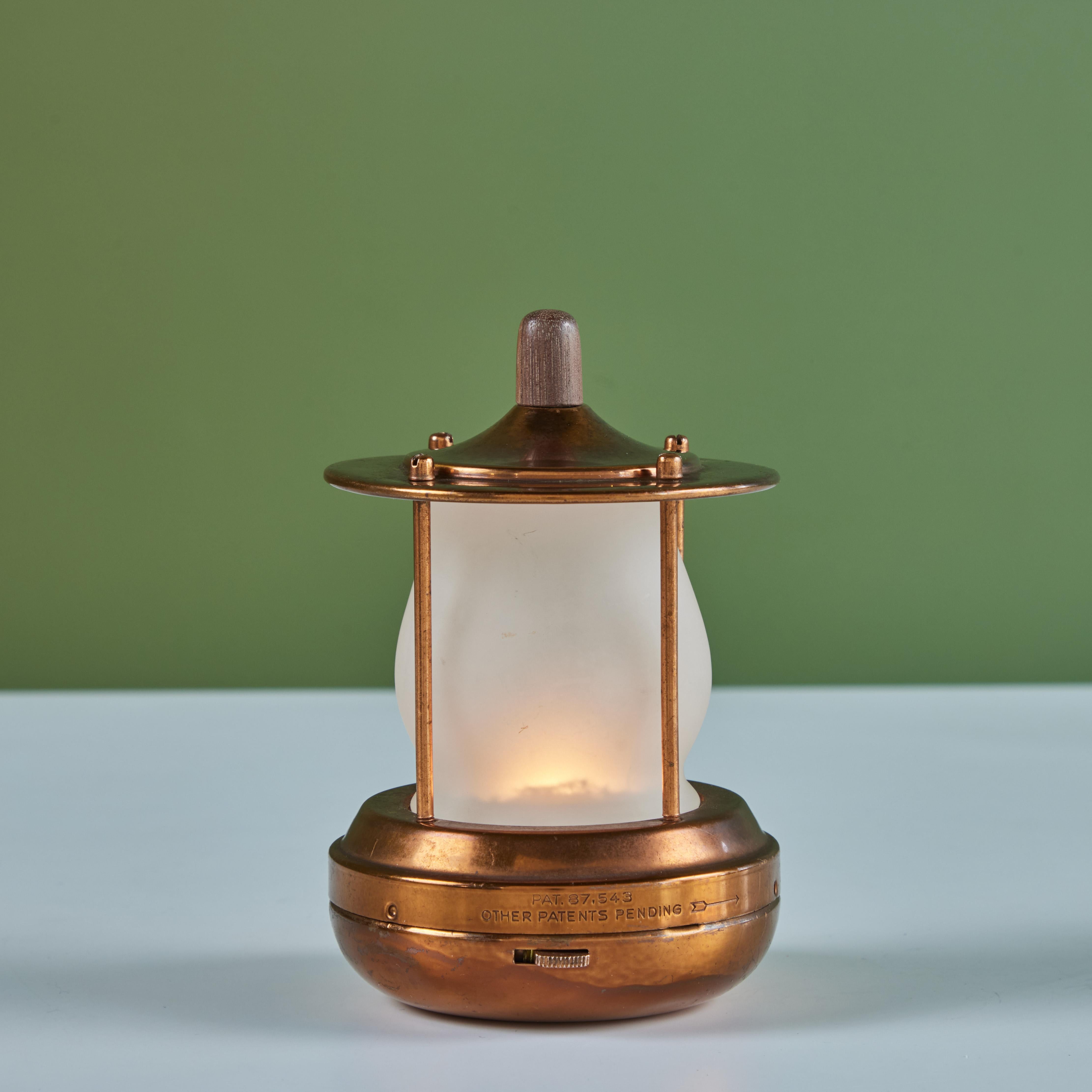 Petite copper lantern style table lamp for Chase, c.1930s, USA. The Art Deco lamp features a cylindrical cone shaped glass with a copper base and cap with hand carved walnut topper. This particular lamp is battery powered with two C batteries so it