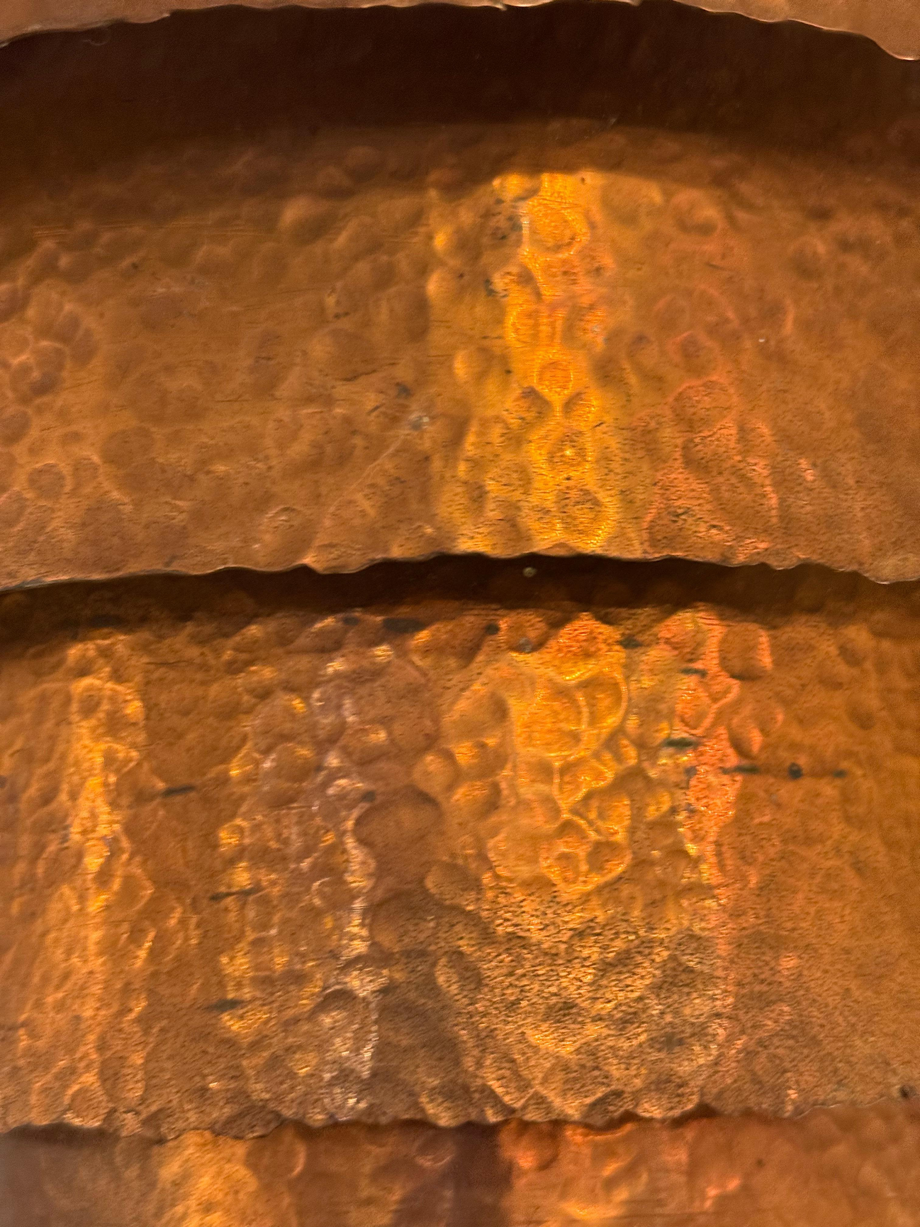 A handcrafted, layered wall sconce in hammered copper with a warm patina. The stepped design diffuses light beautifully, casting a rich glow.


