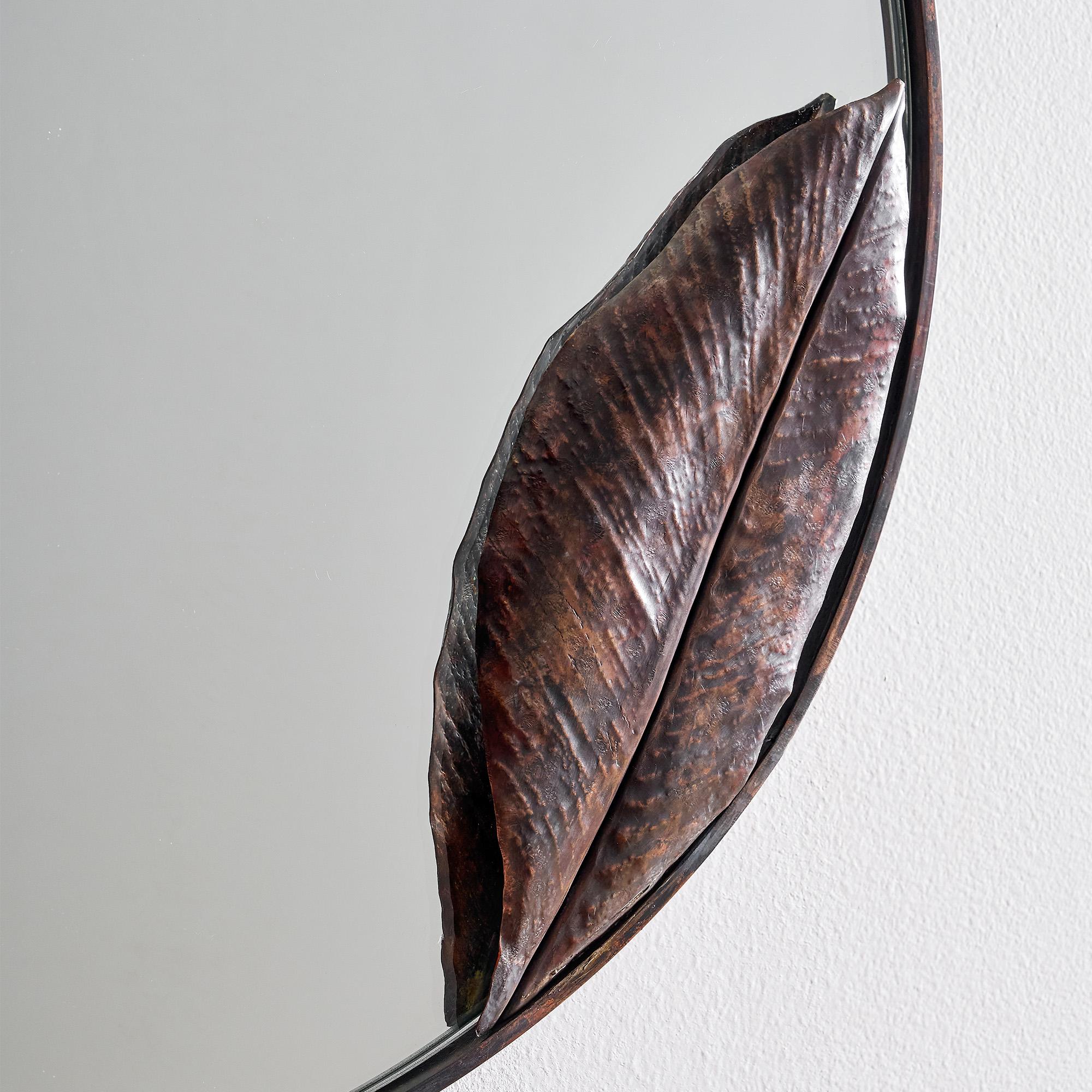Handcrafted of copper, this Copper Leaf Round Mirror features a single folded leaf gently arching over the glass. Inspired by botanical form and crafted with precision, this piece is both functional and deeply expressive, a reflection of nature’s