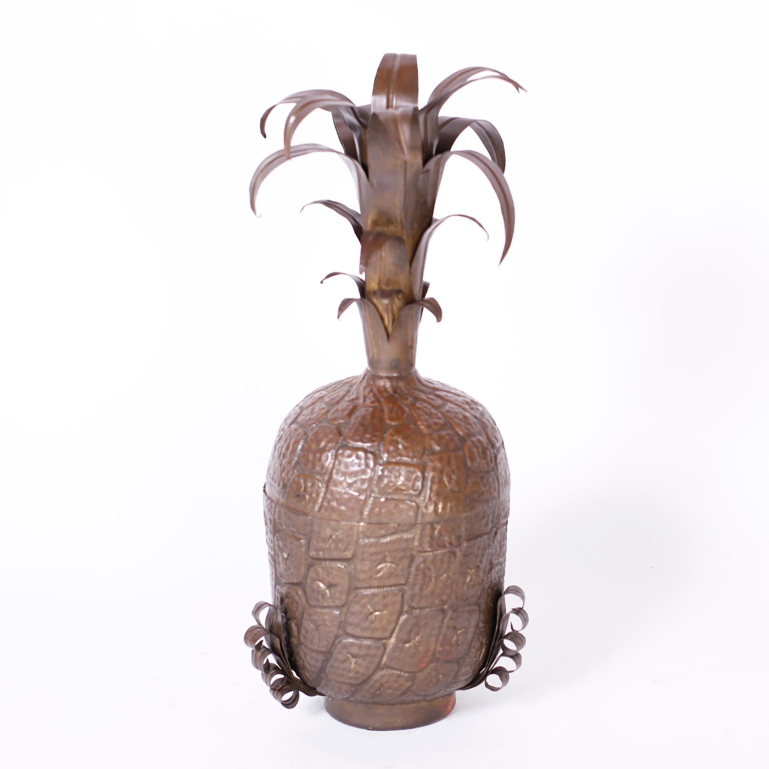Midcentury lidded pineapple expertly crafted in copper, hand hammered and decorated with stylized leaves and retaining its bronze like patina.