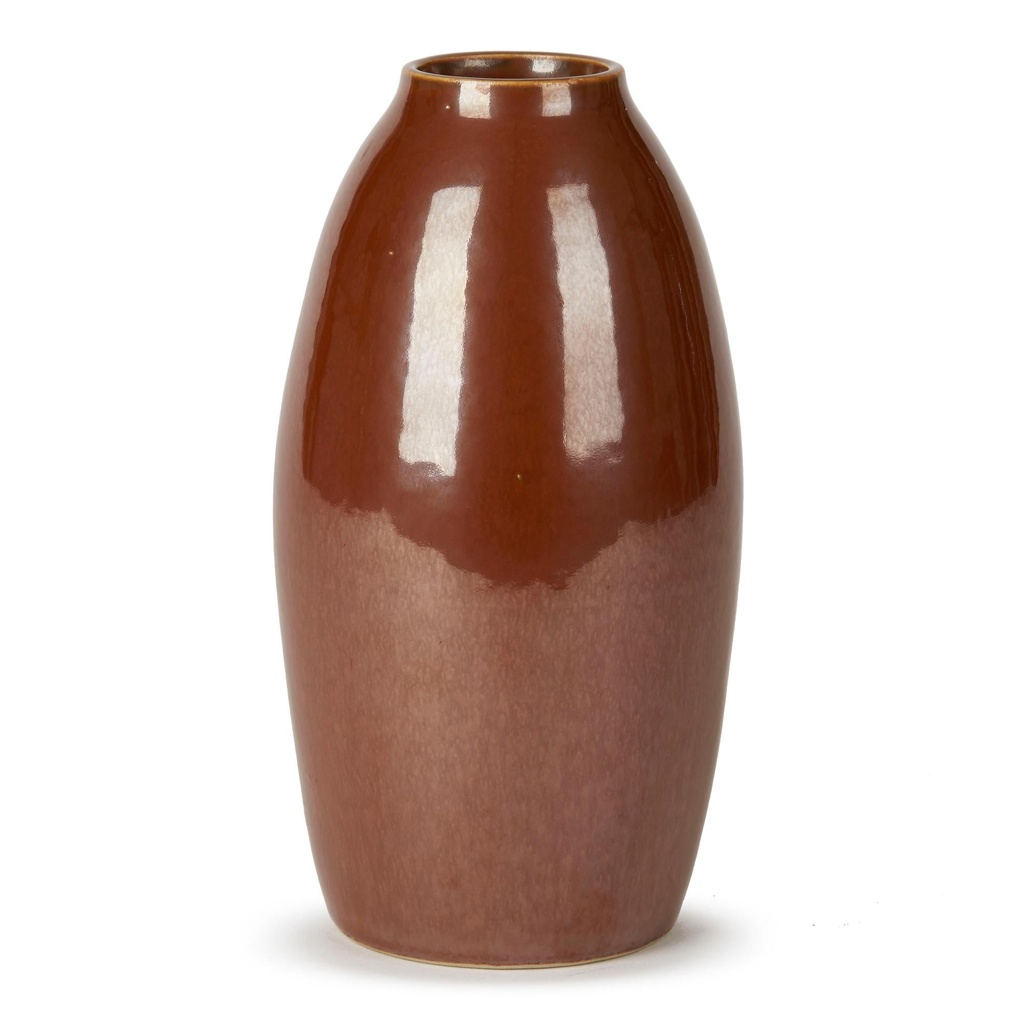 Fino y elegante jarrón de cerámica artística sueca de mediados de siglo diseñado por Carl-Harry Stålhane (1920-1990) para Rörstrand. Este sencillo jarrón de forma ovalada está ricamente decorado con un vidriado de reflejo cobrizo marrón chocolate y