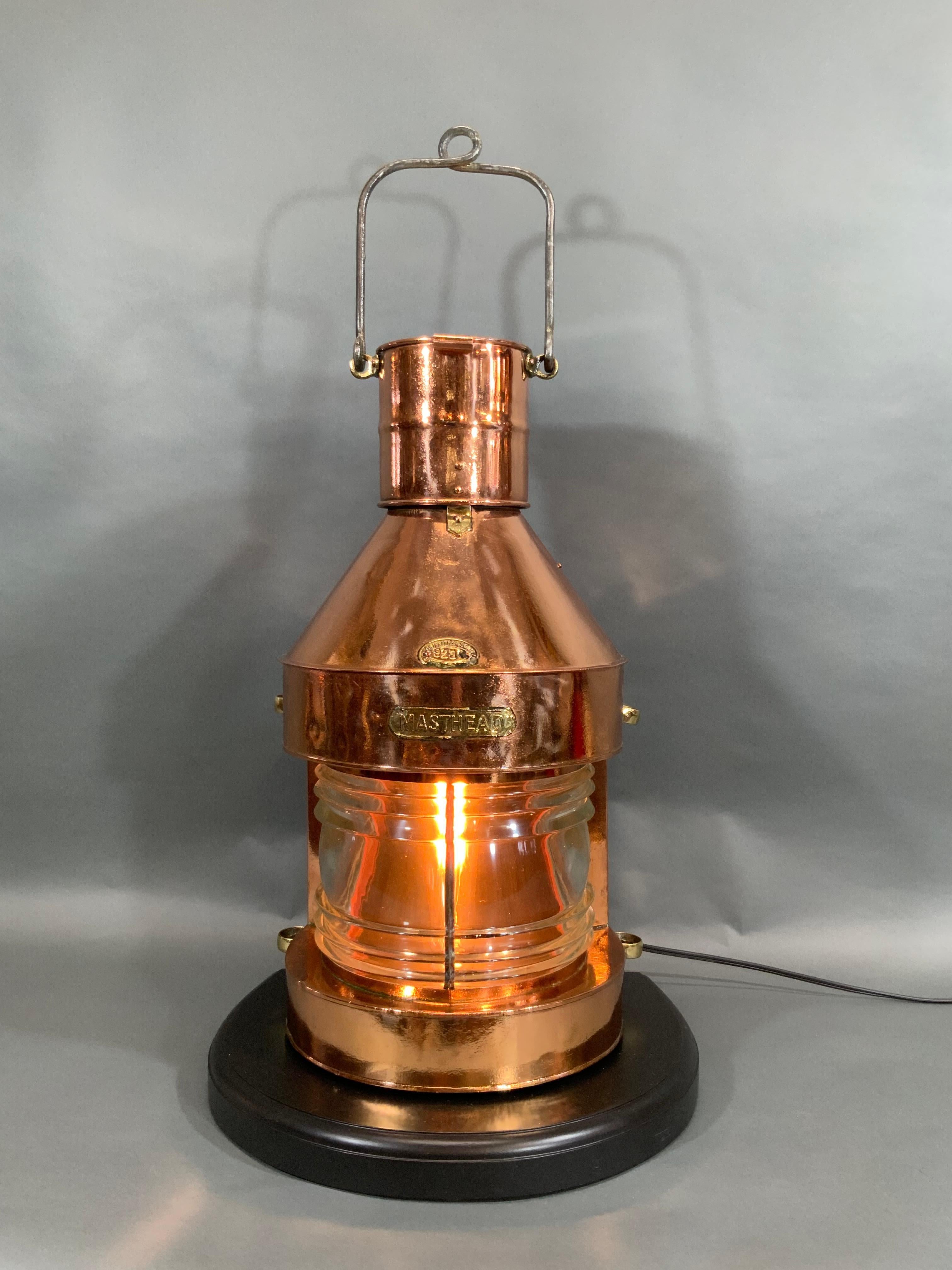 Ship's lantern known as a masthead lantern with Fresnel glass lens. Meticulously polished and lacquered, and wired with electric cord for home use. With chandler's badge from Griffiths and Sons of Birmingham, England. Also has a brass 
