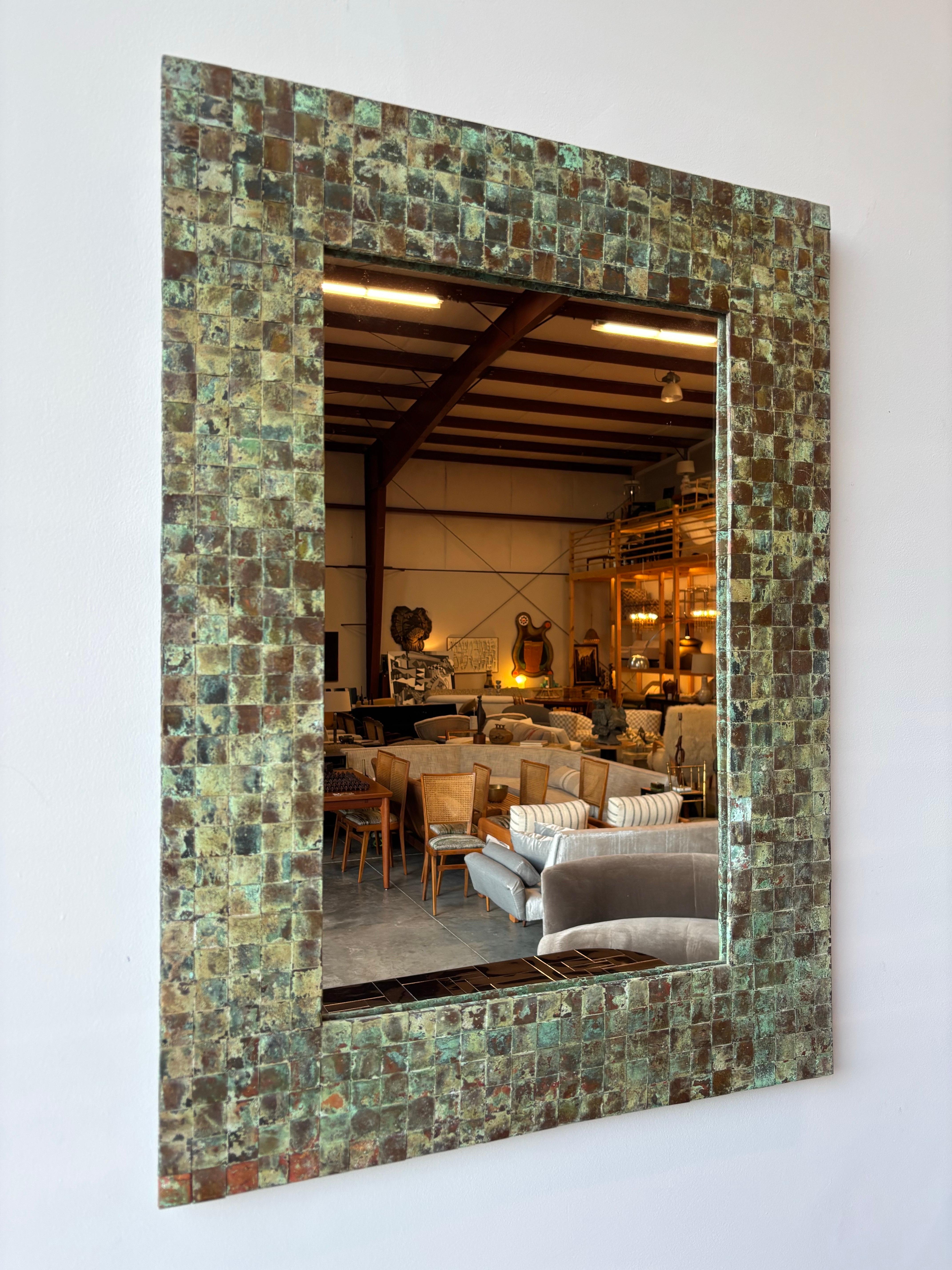 
This extraordinary vintage wall mirror showcases the beauty of aged copper through its distinctive woven frame design. Measuring a substantial 38 inches by 28 inches, this piece commands attention with both its scale and the rich sculptural quality