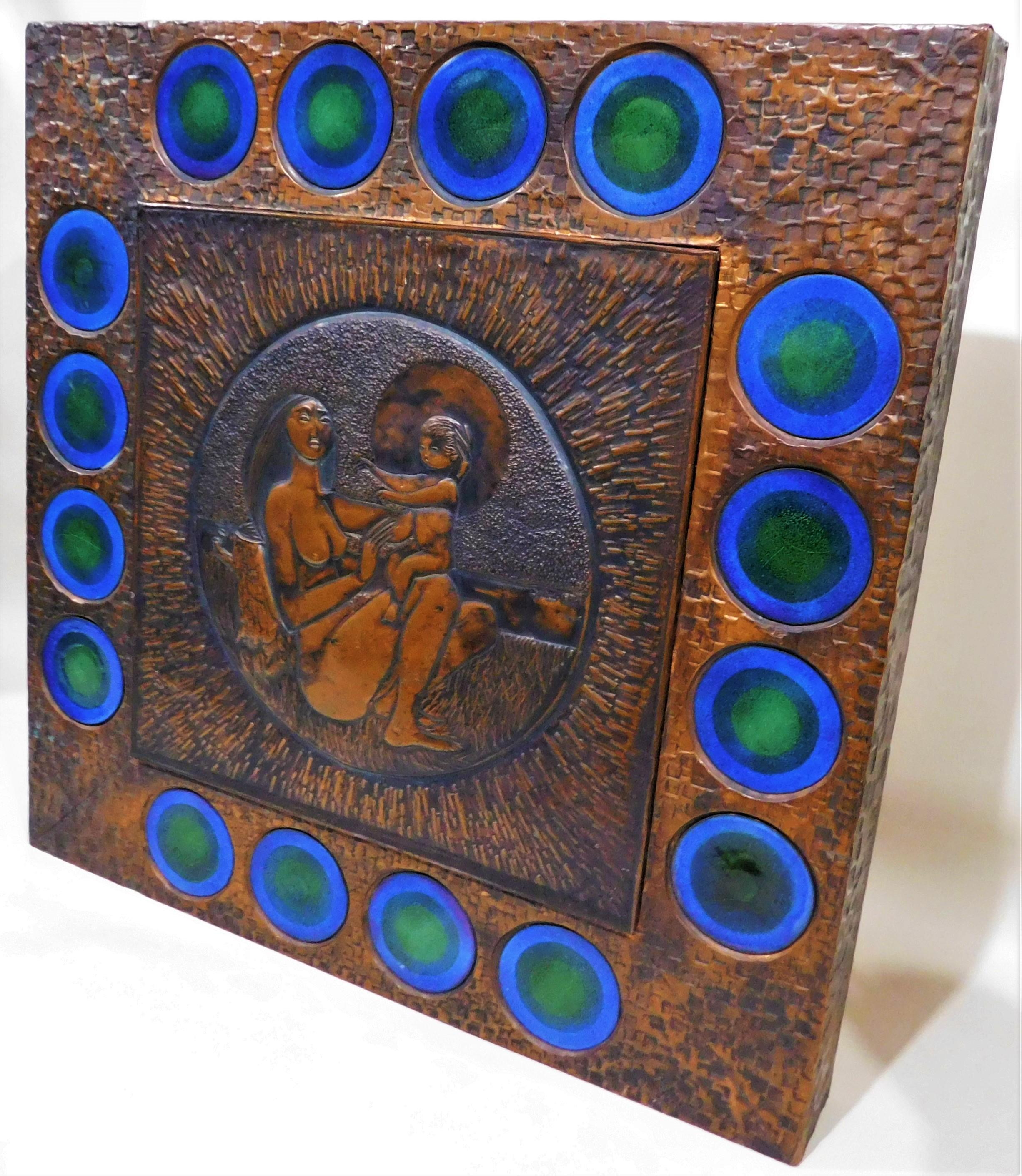 Copper-muralist artist Laszlo Buday came to Canada in 1957 from his native Budapest, Hungary. This original piece is a hand-hammered signed copper metal work on wood of a nude woman and child, with 16 blue enamel pieces surrounding the inner