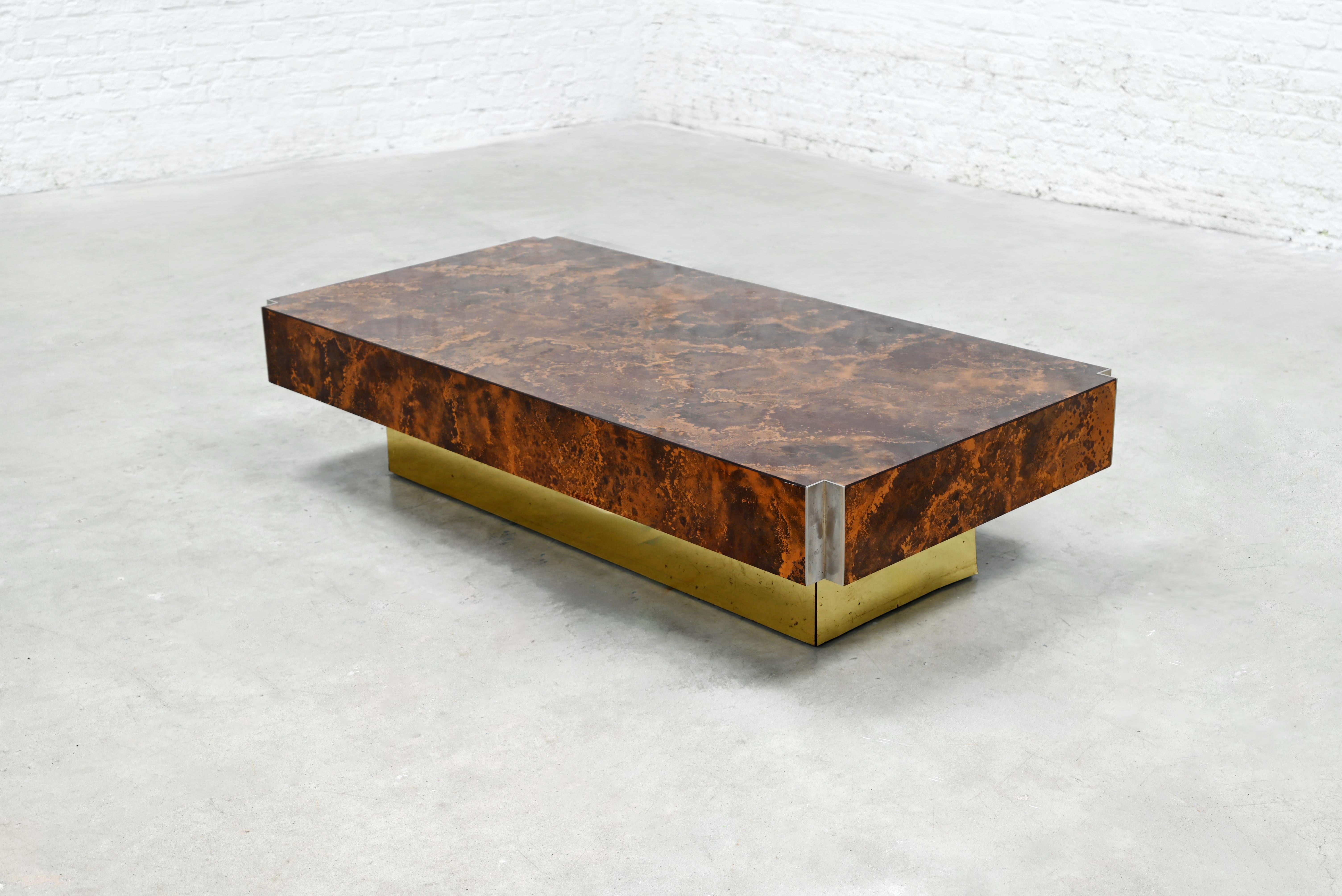 Designed by Guy Lefèvre for Roche Bobois in the 70's, this low table features a rectangular top with a textured copper oxide finish inlaid in formica, set over a recessed brass-plated base. The surface, visually rich and organic in tone, is