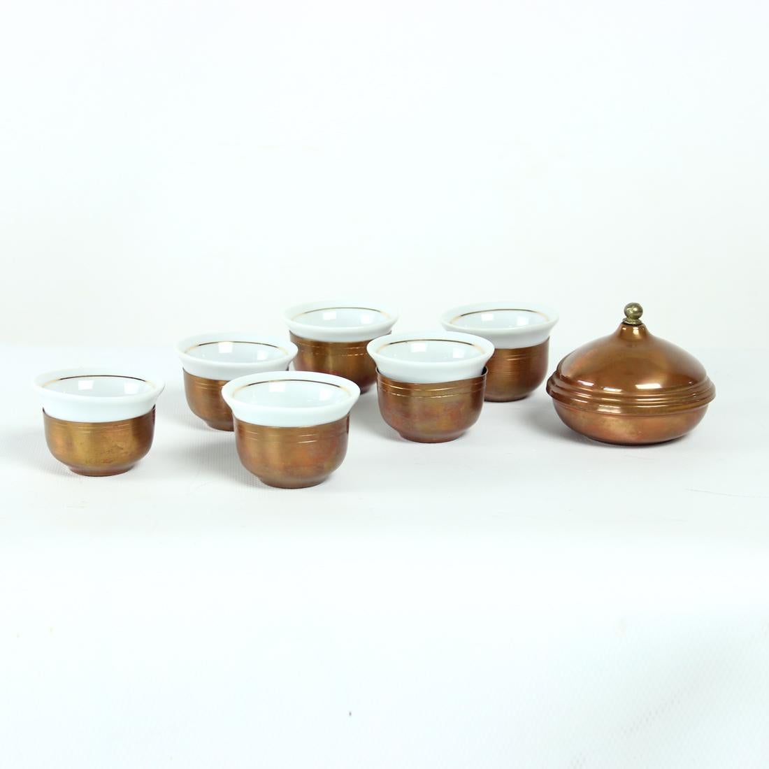 Beautiful vintage espresso cups (set of 6) with a sugar jar. The cups are made of white porcelaine with gold rim. Each cup sits in a copper cup. this not only looks very pretty, but allows you to hold the cup comfortably with hot drink inside. The