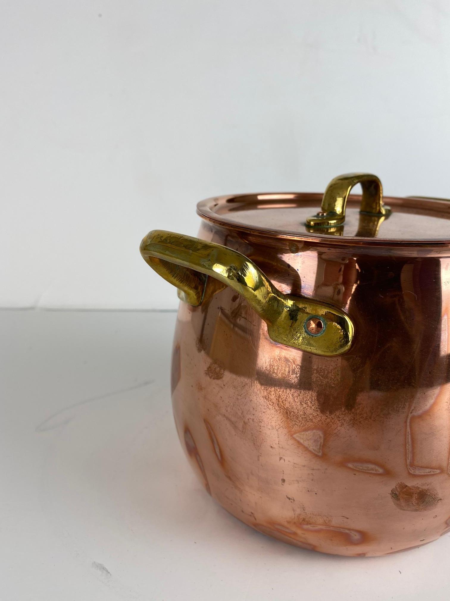 Copper pot with a lid. A brass handle on each side.