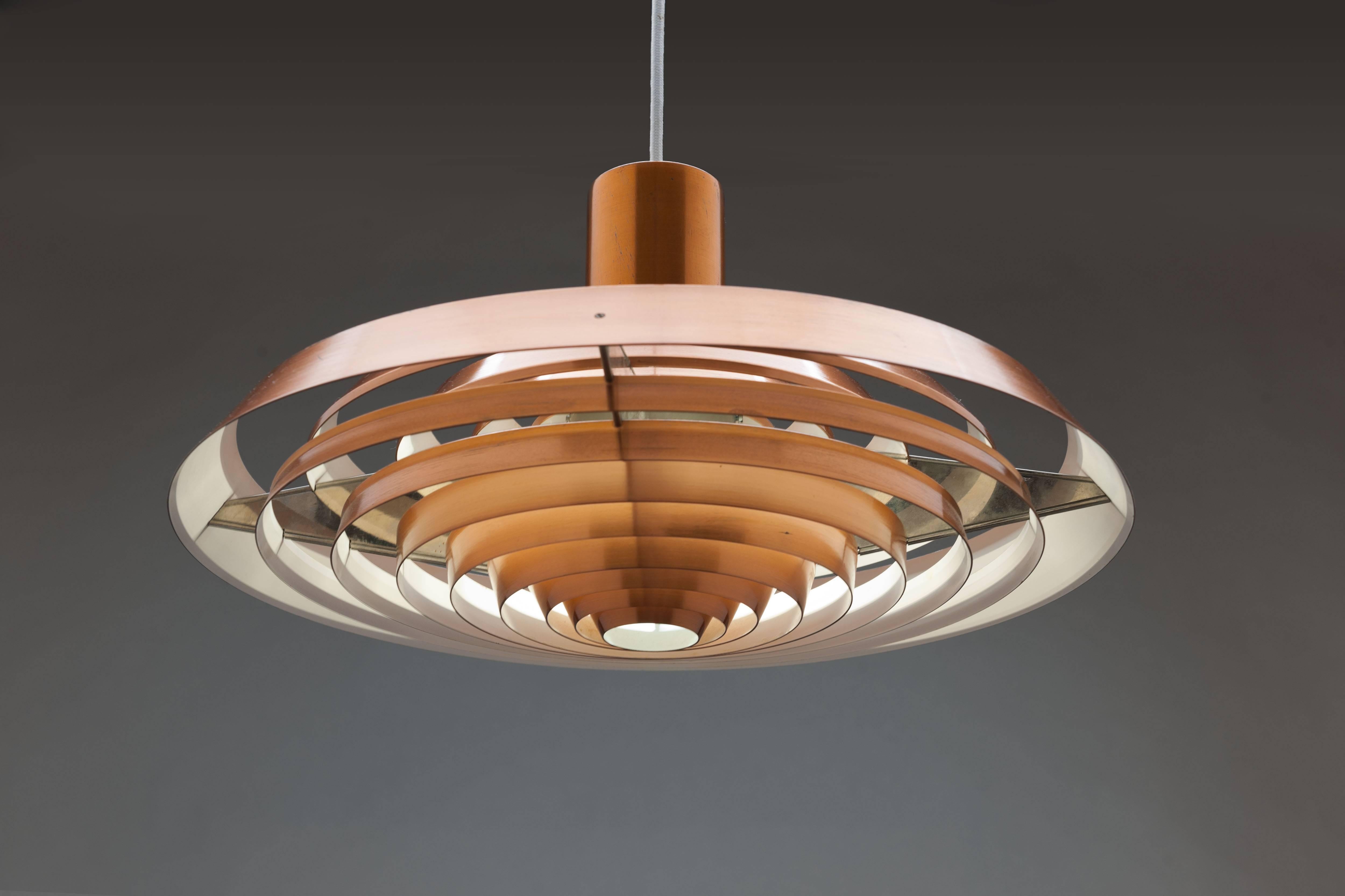 Copper Langelinie plate pendant by Poul Henningsen for Louis Poulsen originally designed in 1958 for the Langelinie Pavilion in Copenhagen and inspired by the pattern of rings in the water surrounding the Pavilion. This lamp was produced in the same