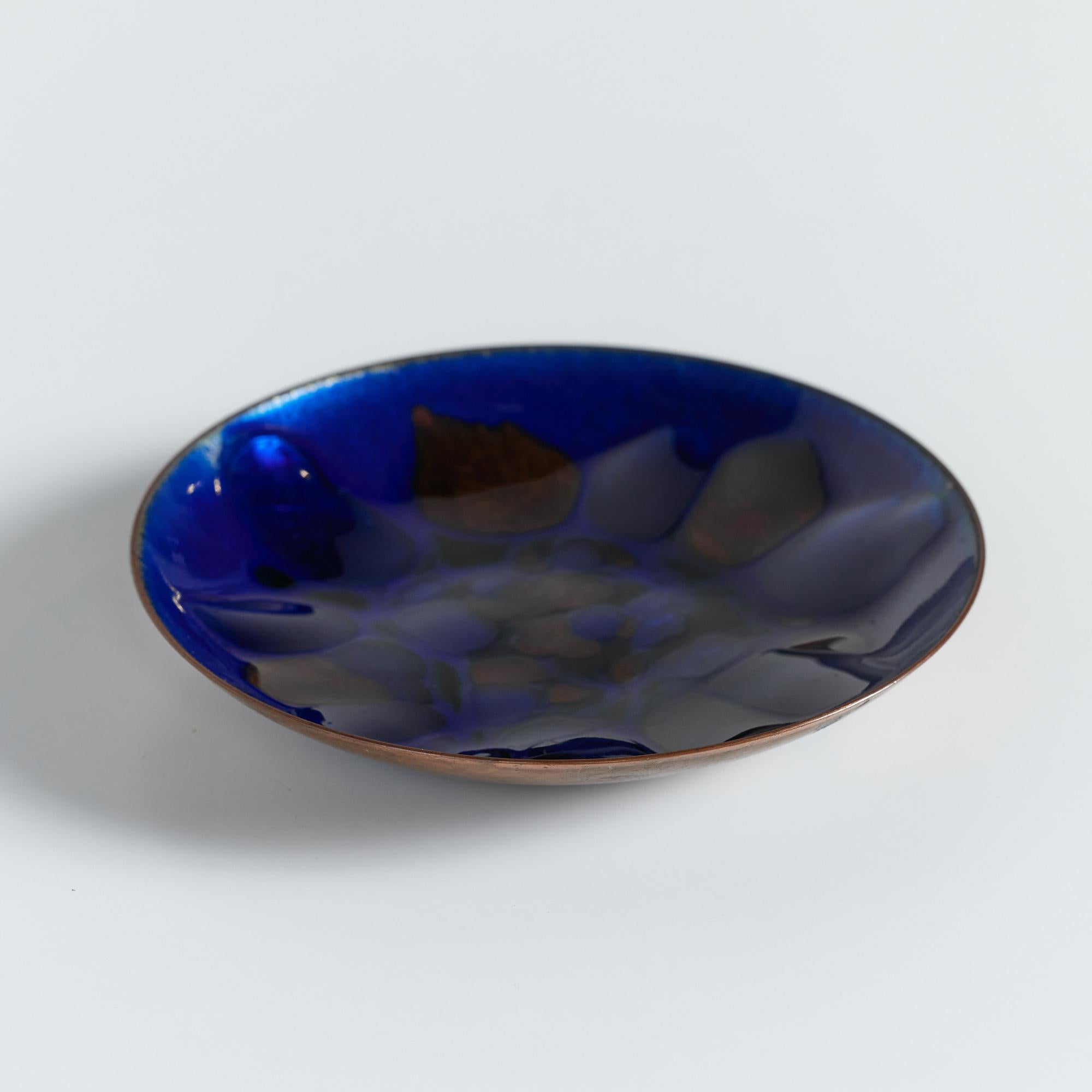 Copper plate by San Francisco artist Win Ng, circa .1960s USA. A beautiful royal blue enameled catchall or simply a décor piece. The dish features a technique that creates an asymmetrical pattern by fusing powdered glass to metal.
Signed Win Ng San