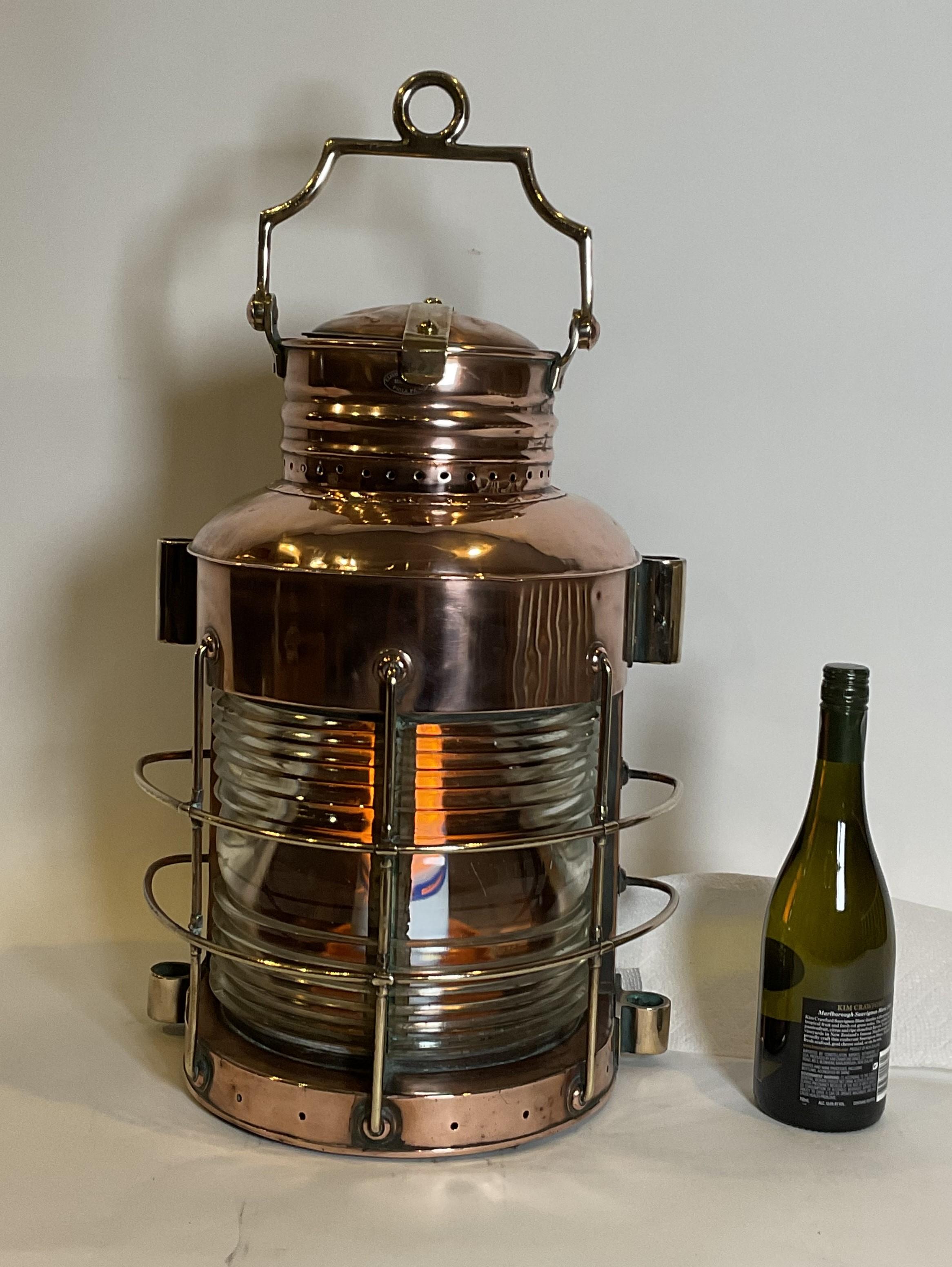 Massive polished copper ships masthead lantern. Fitted with fresnel glass lens. Large vented top, heavy brass carry handle, door to rear. Sturdy brass mounting rings. 

Weight: 25 lbs.
Overall Dimensions: 21