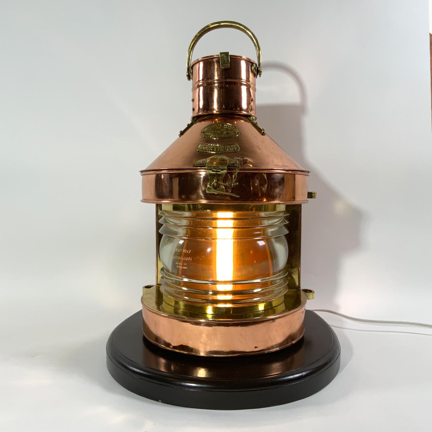 High quality solid copper and brass trimmed masthead lantern. With maker's badge from Tung Woo Masthead and Serial No. M123. Thick Fresnel lens, hinged top vented chimney, brass carry handle. Mounted to a thick wood base. Meticulously polished and
