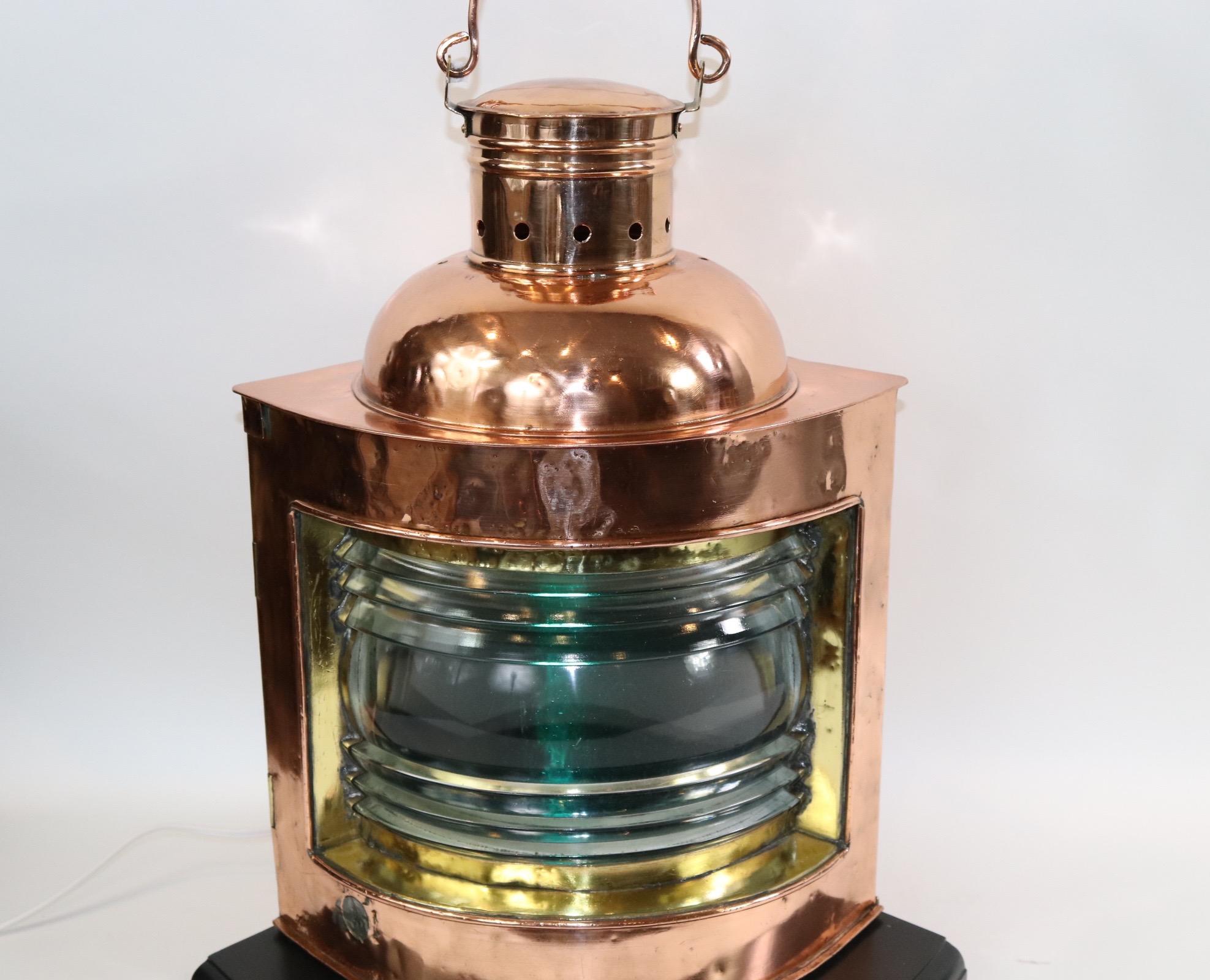 Highly polished and lacquered solid copper ships lantern with clear Fresnel glass lens and removable green filter. The copper bodied lantern has brass bezel, hinges and handle. Mounted to a thick wood base and wired with new socket and wired for