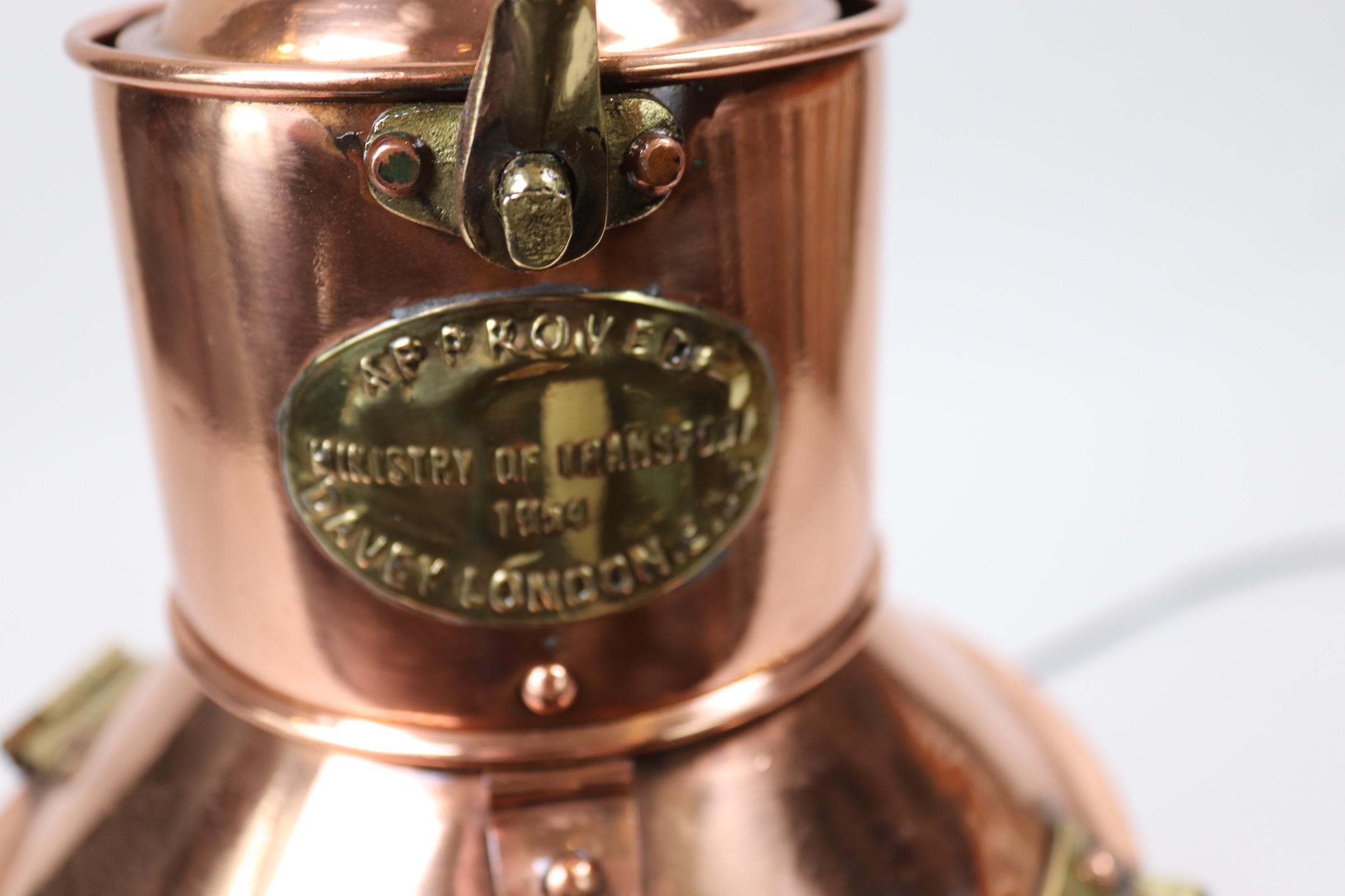 Solid copper highly polished and lacquered ships signal lantern with brass makers badge from Davey of London, Ministry of Transport, 1954, with thumb operated shutter mechanism, hinged top, carry handle etc.. Electrified for home use. Weight is 12