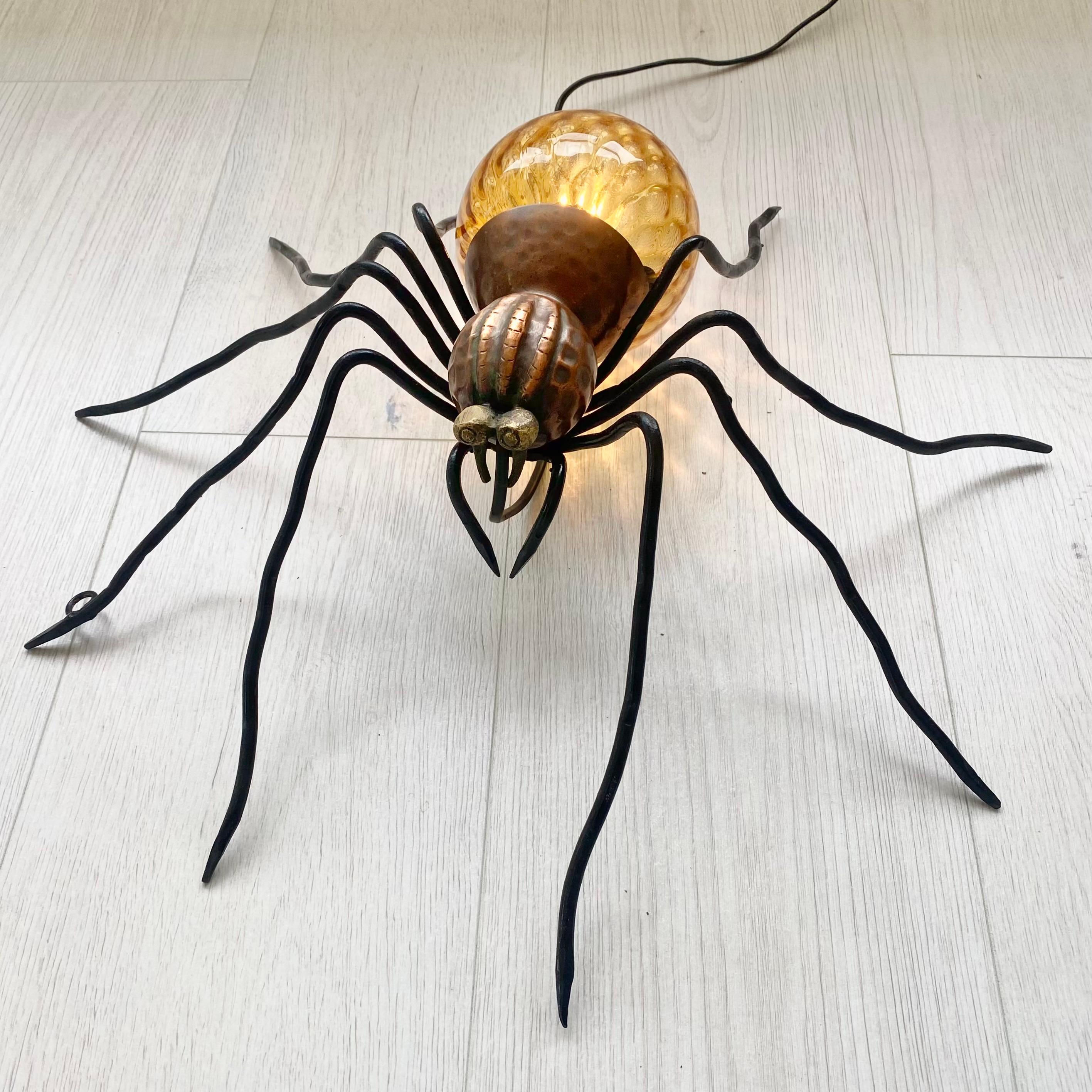 Imaginez cette araignée installée dans une pièce sombre, diffusant une chaude lueur jaune. Il s'agit d'une merveilleuse pièce de conversation et d'un éclairage d'ambiance parfait. Grande présence et détails. Corps en cuivre martelé, tête noire et