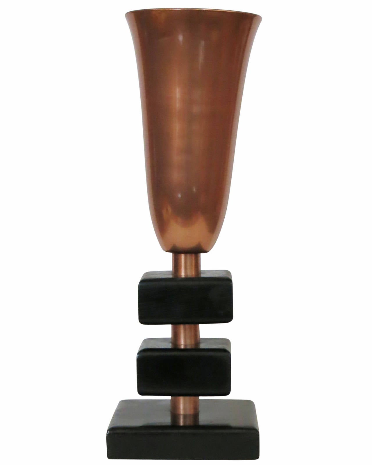Lampe de table torchère en cuivre de la fin des années 1940, dotée d'un abat-jour torchère élancé en cuivre et d'une base empilée en bois laqué avec des liens décoratifs en cuivre. 

Cette lampe est un excellent exemple du design du milieu du