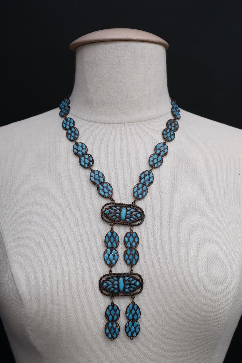 Ancient necklace from the 1925s, composed of copper-tone metal and turquoise glass paste. No signature.

Additional information: 

Dimensions: 
Length: 50 cm (19.68 in), Pendant: 13 cm x 4.5 cm (5.11 in x 1.77 in) 

Condition: 
Very good condition,