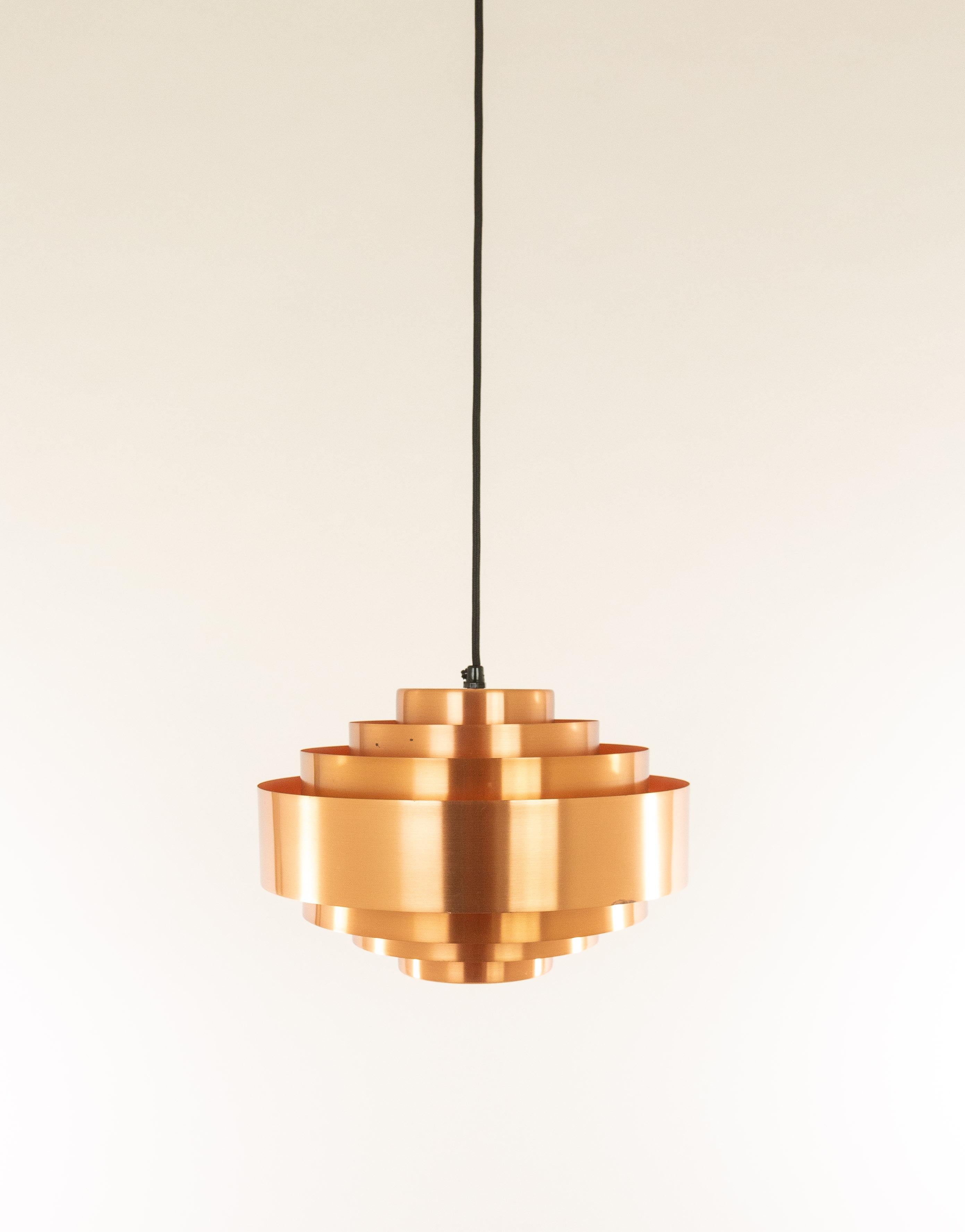 This 'Ultra' pendant was designed by Jo Hammerborg for Fog & Mørup in the very early 1960s.

The lamp consists of seven rings. Ultra was produced in solid copper and lacquered aluminum. This is the copper version with an orange inner.

The lamp