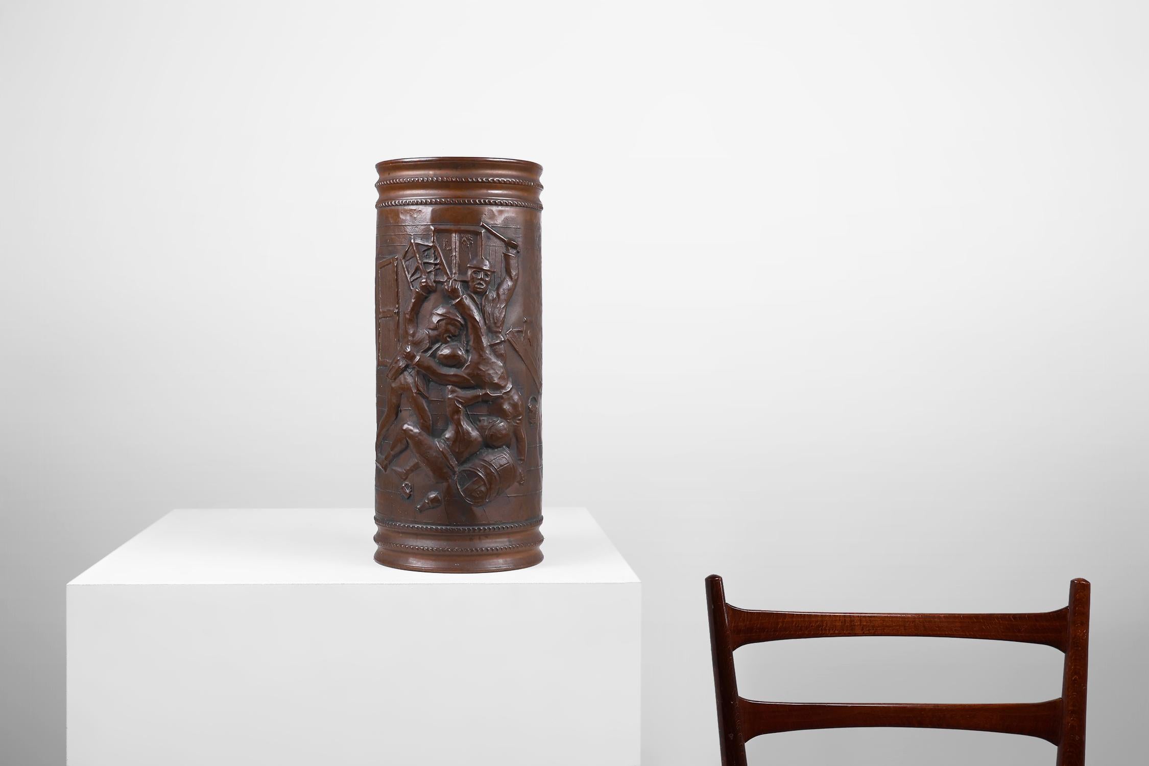 France / 1900 / umbrella stand / copper / Rustic / Mid-Century

A rustic copper cylinder shaped umbrella stand crafted around 1900 in France.

This very decorative object features a hammered image of  bar fight in a medieval café.