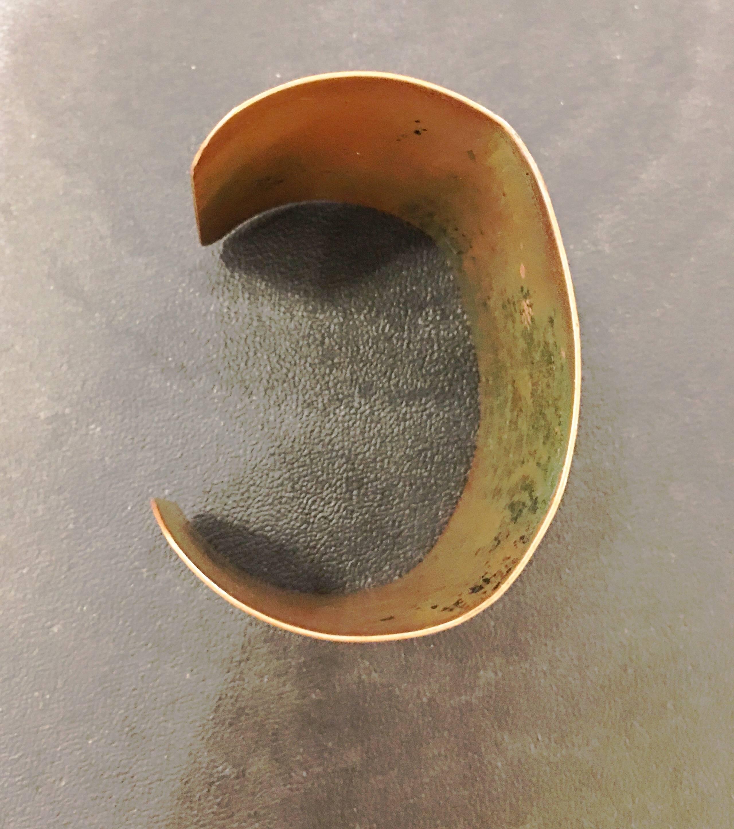 Imprinted copper cuff bracelet with leaf/floral designs around the edges, stripes down the middle. Some sides of aging on the inside of the cuff and some very minor oxidation on the outside in some of the ridges of the stripes. Some
