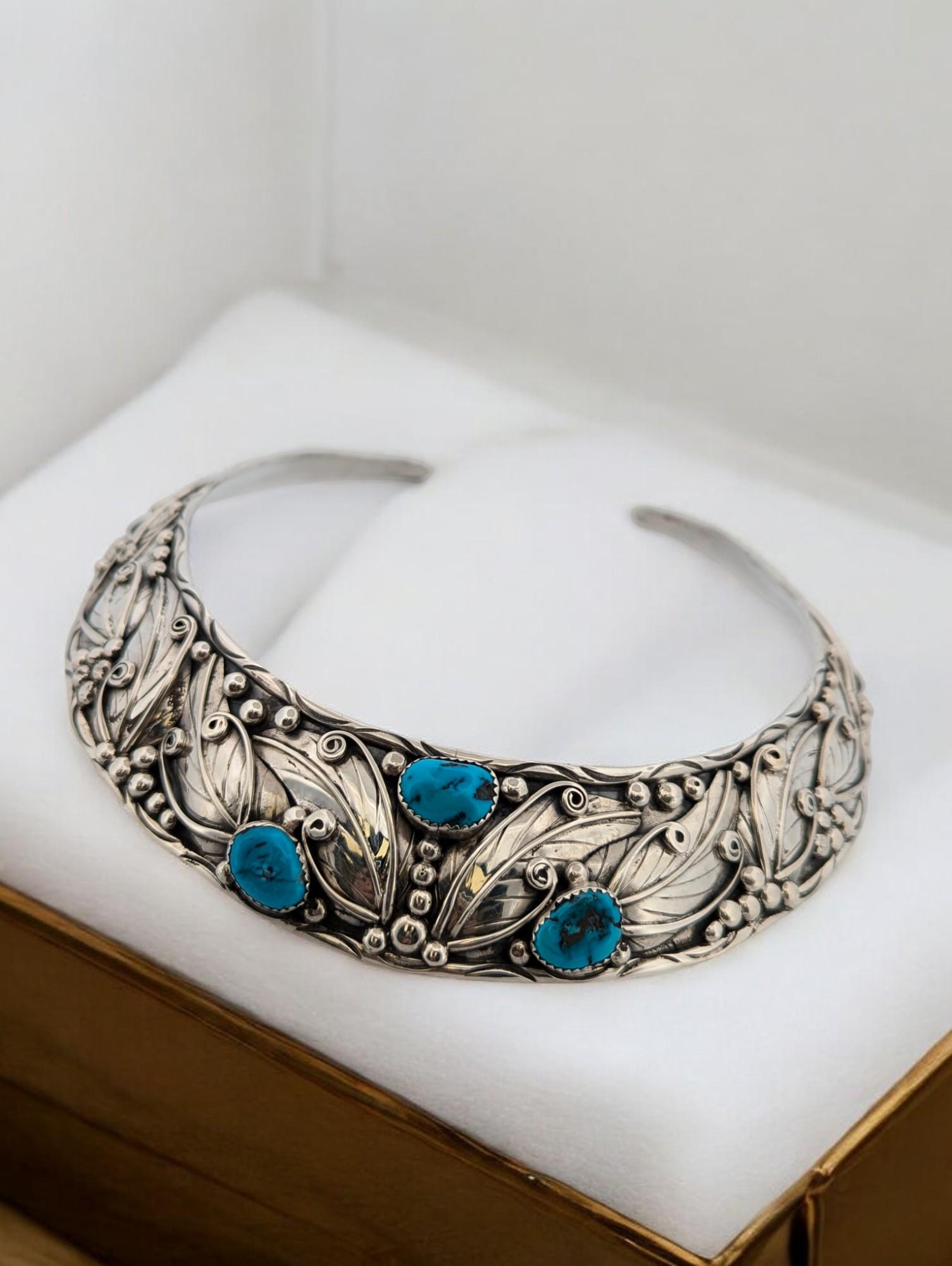 Add a touch of timeless elegance to your collection with this vintage sterling silver handmade neck torc. Featuring three stunning blue cabochon turquoise coins, this piece showcases a perfect balance of bold style and intricate craftsmanship. The