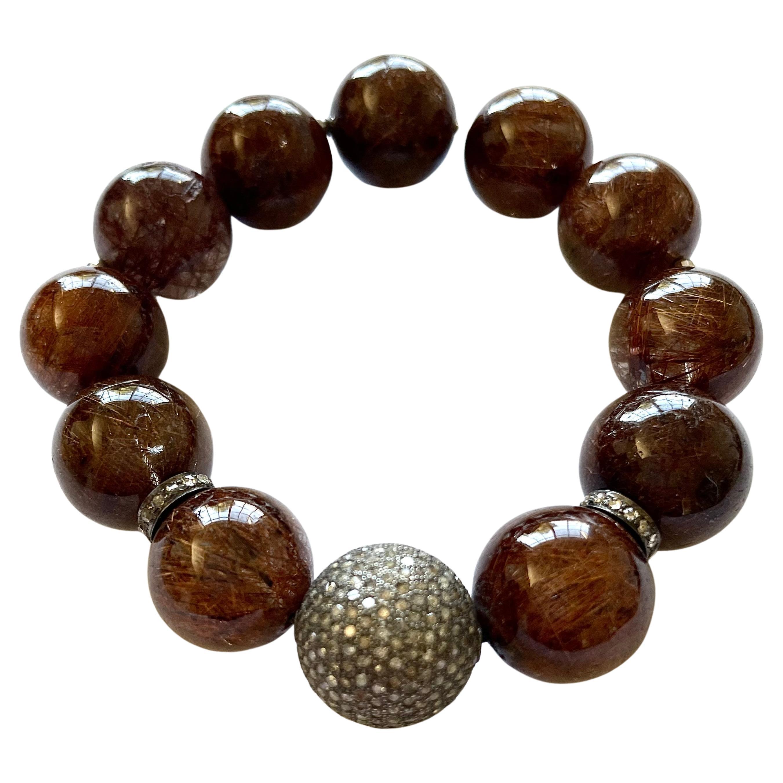 Description
This superior quality, rare coppery-brown Rutilated Quartz, dramatically accented with a stunning, large 16mm pave diamond ball and pave diamond rondelles makes this stretchy bracelet a fashion must have on your wrist.
Item #
