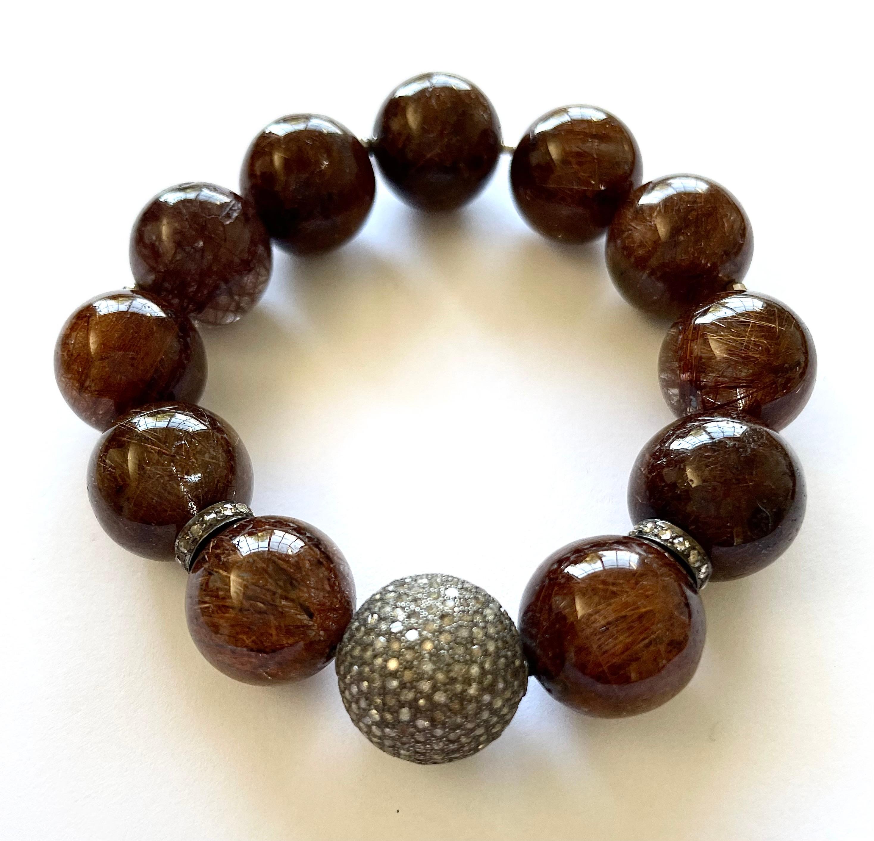 Description
This superior quality, rare coppery-brown Rutilated Quartz, dramatically accented with a stunning, large 16mm pave diamond ball and pave diamond rondelles makes this stretchy bracelet a fashion must have on your wrist.
Item #