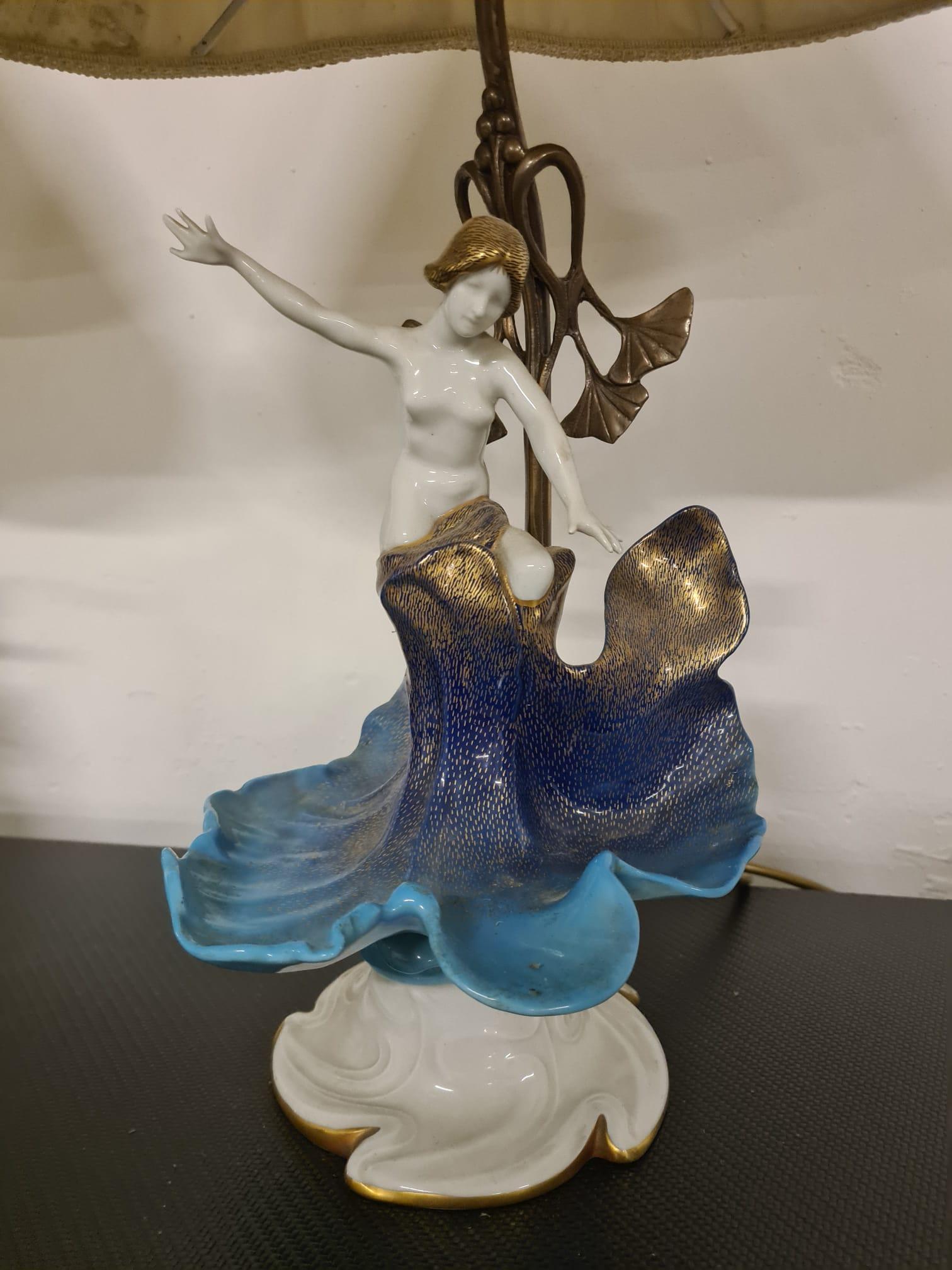 Paire d'abat-jours en porcelaine de la firme Mangani Firenze.

Elégantes lampes de chevet de style Art Nouveau en porcelaine finement peinte à la main.

La porcelaine artistique représente deux nife émergeant d'une fleur d'eau.

Décoré d'émaux dans