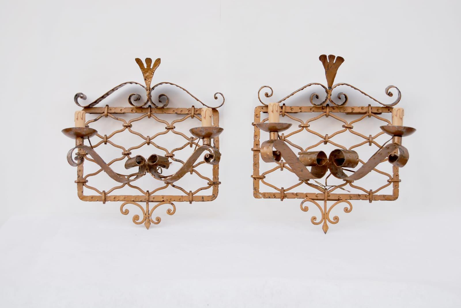 Pair of gilded wrought iron wall sconces, 1950s, Made in Italy. 
Wall sconces in the style of Pierluigi Colli made of gilded wrought iron, completely handcrafted. The rhomboid-shaped inner forms hold each other by iron clamps. The fans that cover