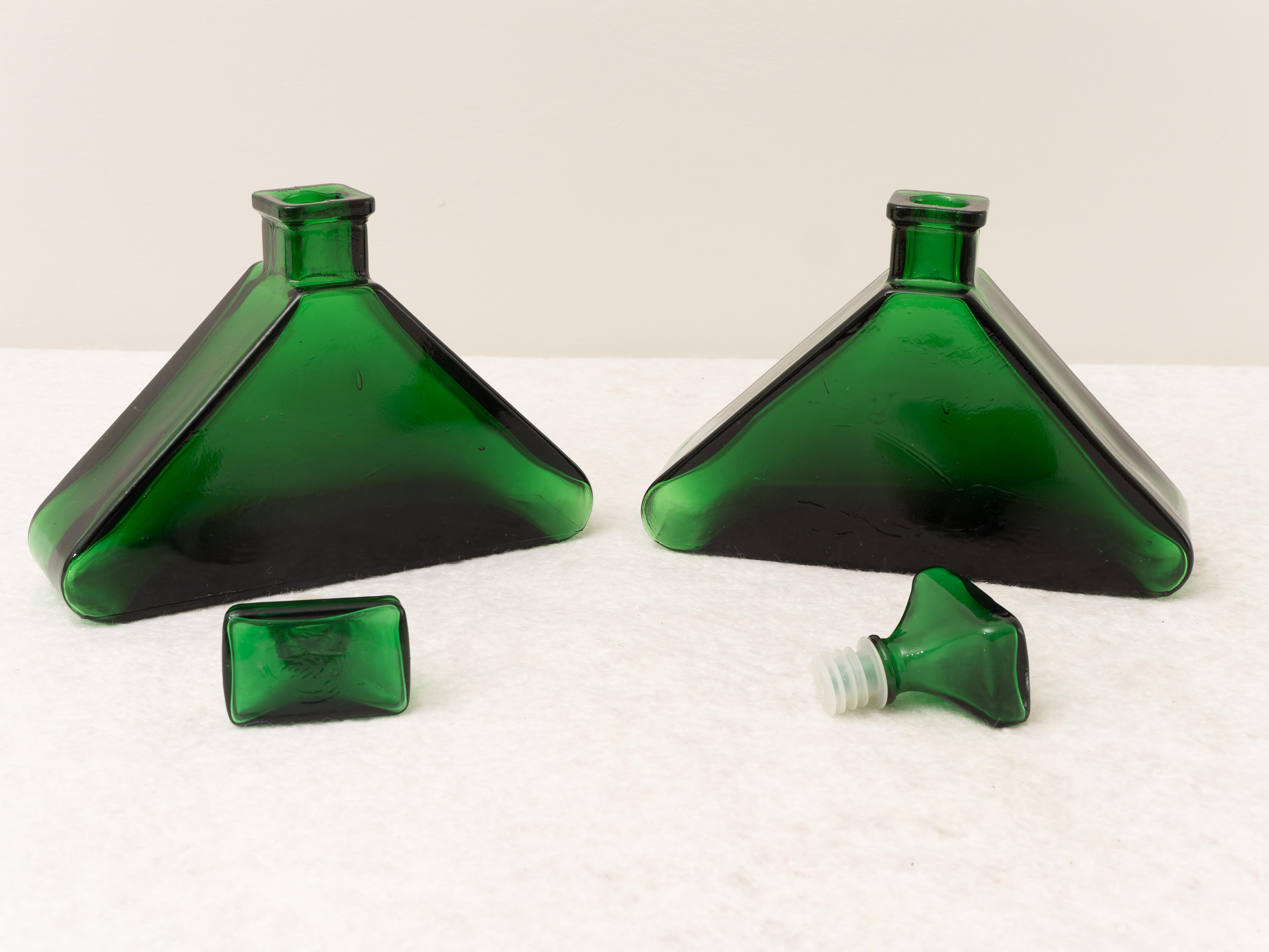 Paire de bouteilles d'ameublement en verre lourd, fabriquées en Italie, années 1970. 
Belle paire de bouteilles en verre vert lourd pour la décoration. La forme très particulière de cet objet peut être utilisée comme meuble pour tout type de