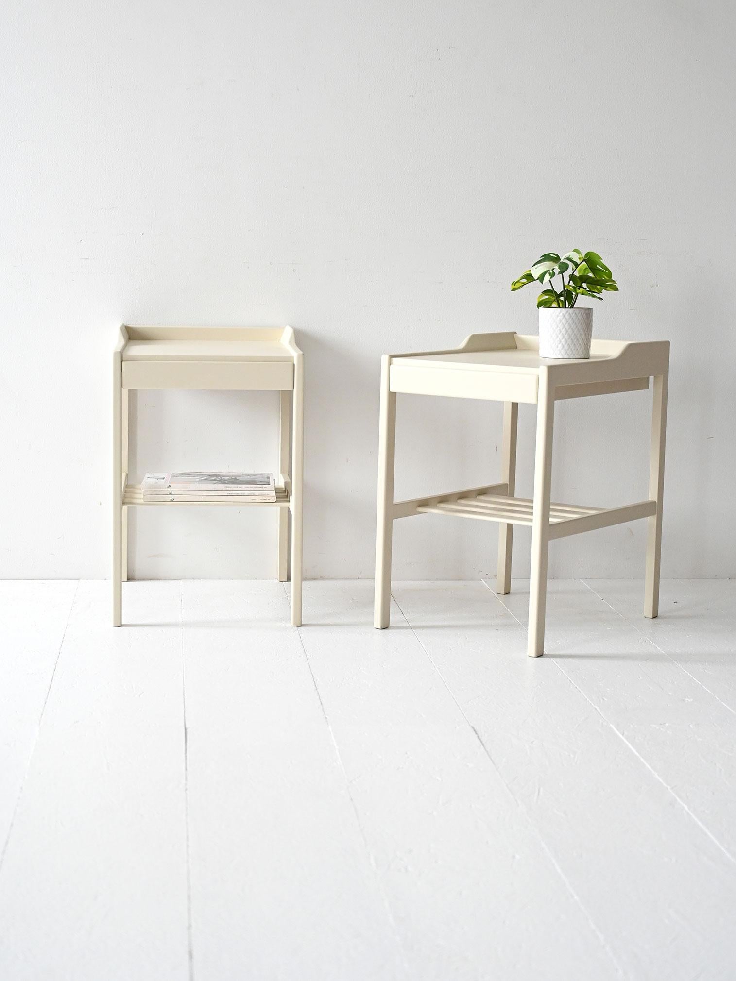Tables de chevet vintage des années 1950 laquées en blanc avec tiroir caché et étagère inférieure à lattes.

Paire de tables de chevet scandinaves originales des années 1950, laquées en blanc. Lignes épurées et proportions harmonieuses, avec un