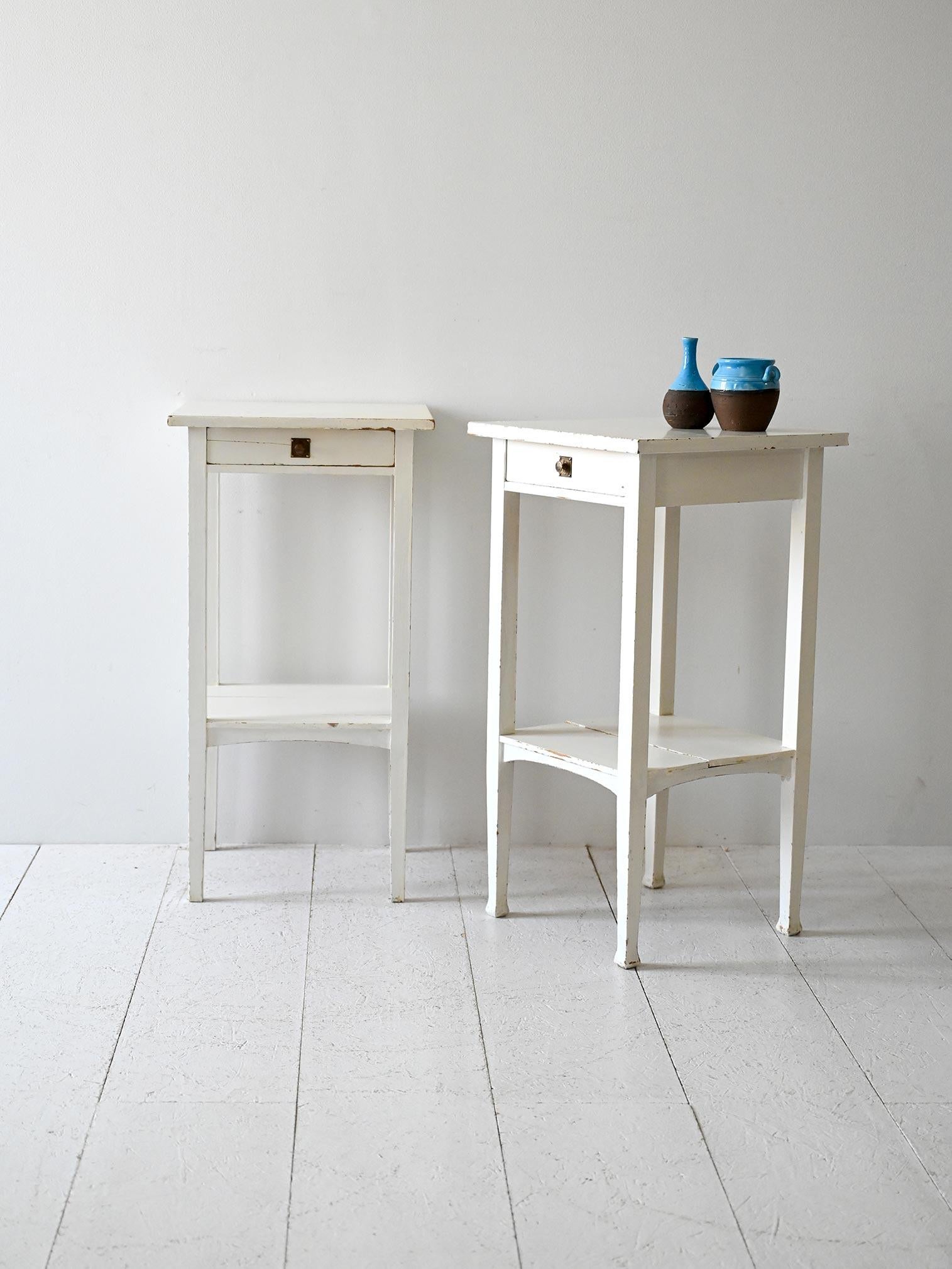 Coppia di comodini in legno verniciato bianco, con cassetto e mensolina, produzione scandinava metà Novecento.

Coppia di comodini scandinavi in legno massello, risalenti alla metà del Novecento. Struttura verniciata di bianco con un cassetto