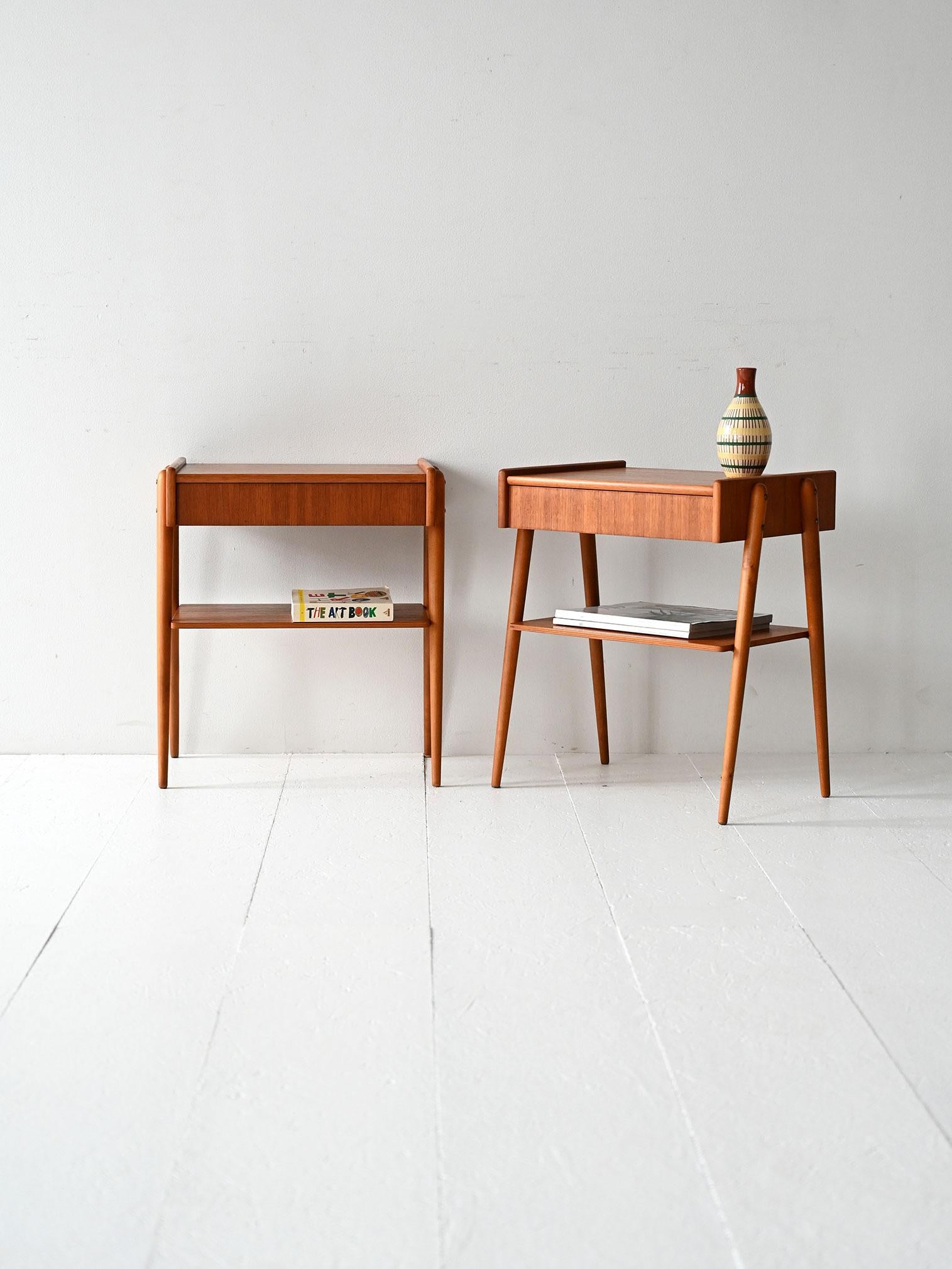 Comodini anni ’60 in teak, con gambe rastremate, cassetto a scomparsa e ripiano inferiore.

Coppia di comodini scandinavi in teak, realizzati negli anni ’60. La struttura snella si distingue per le gambe rastremate e il profilo essenziale. Un